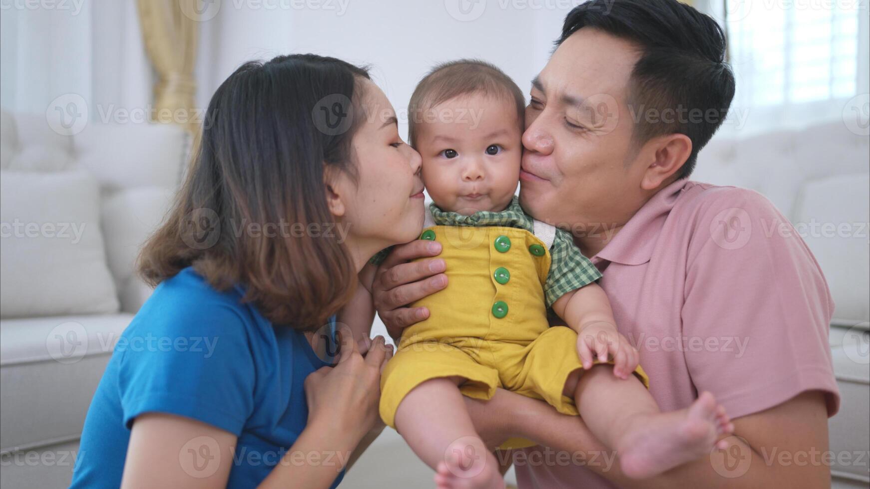 Parents and their little child play happily in the living room of the house photo