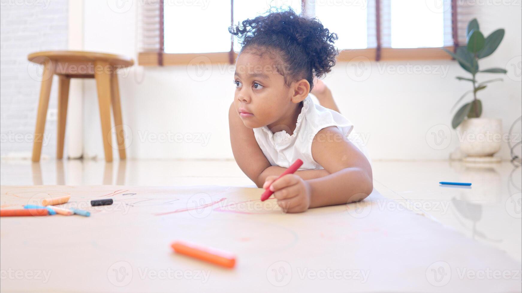 A little girl sit on the floor and drawing together in the living room photo