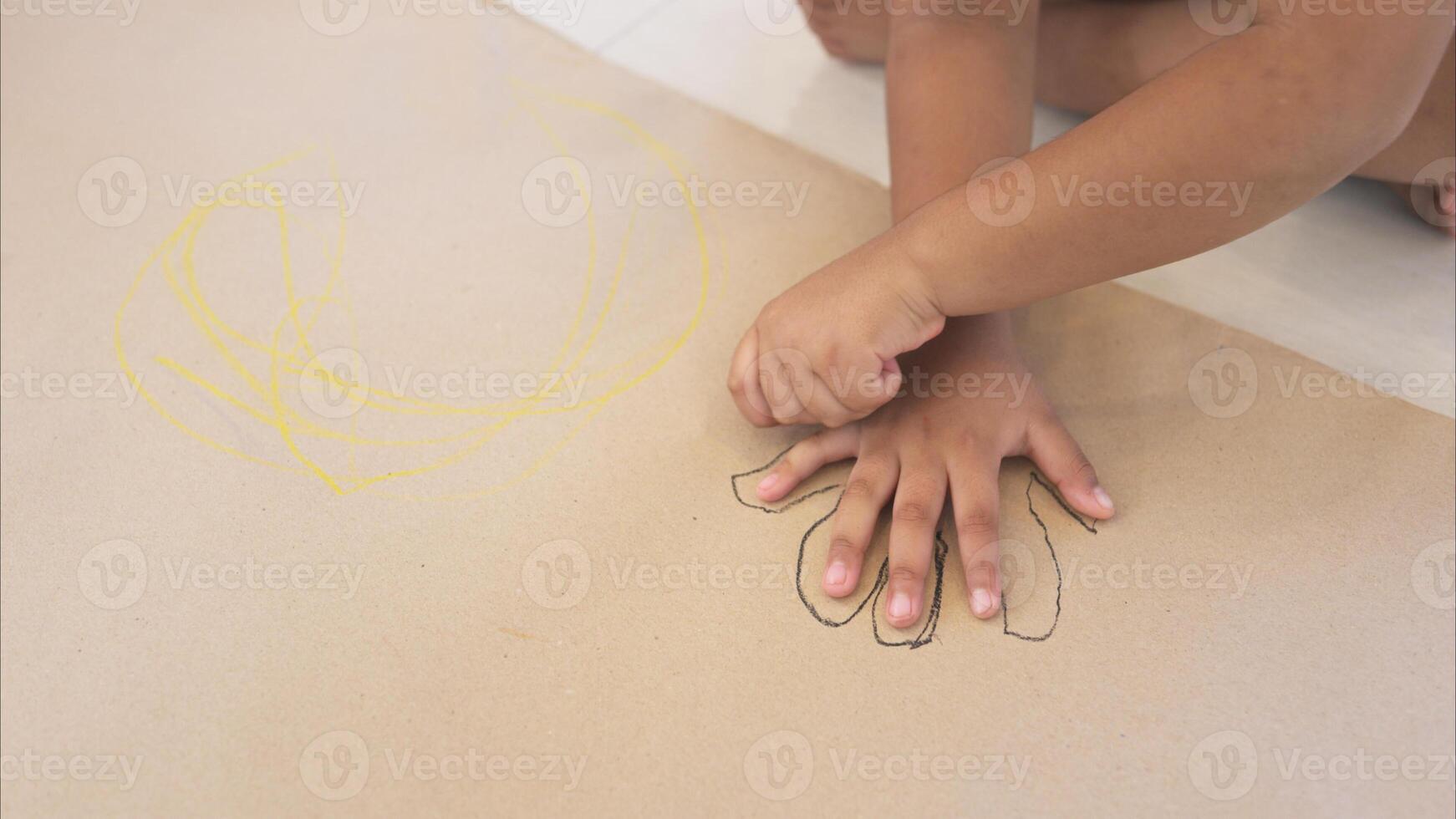 A little girl sit on the floor and drawing her hand in the living room photo