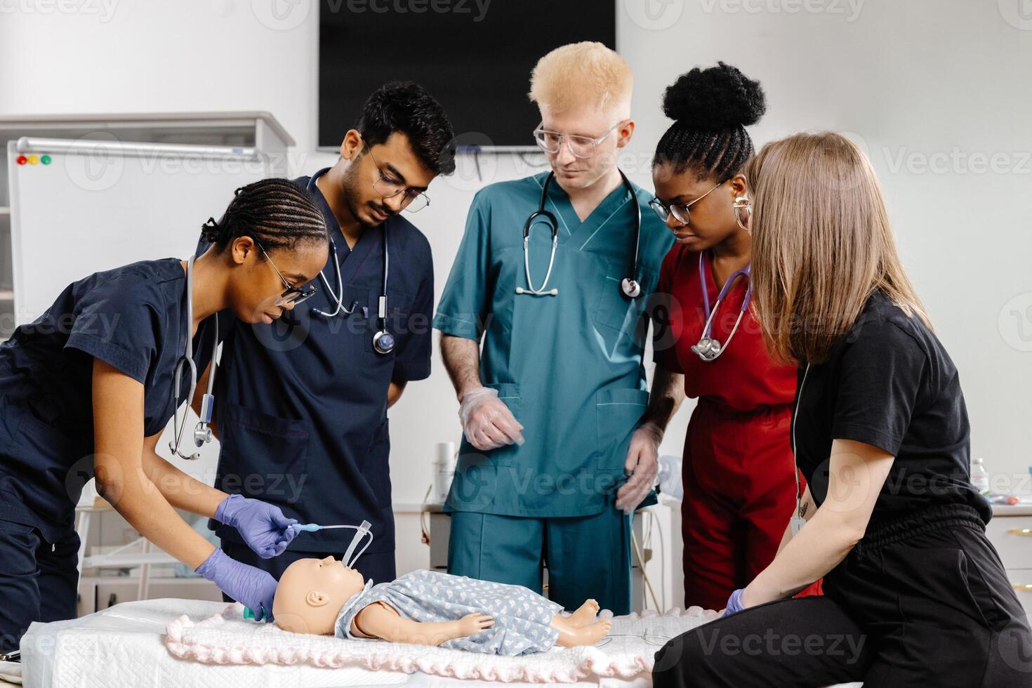 Group of doctors surrounding baby for medical examination photo