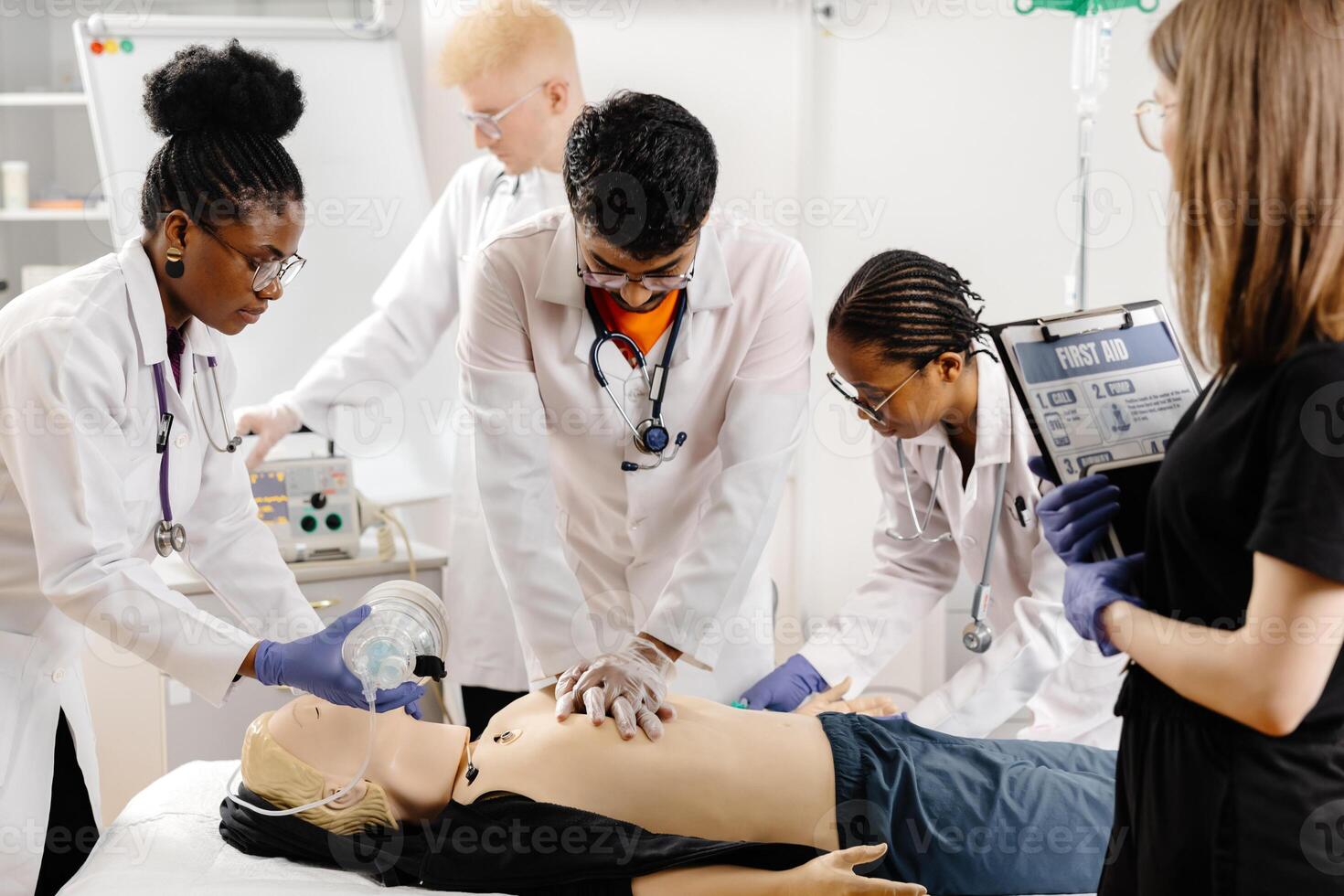 Group of people learning how to make first aid heart compressions with dummies during the training photo