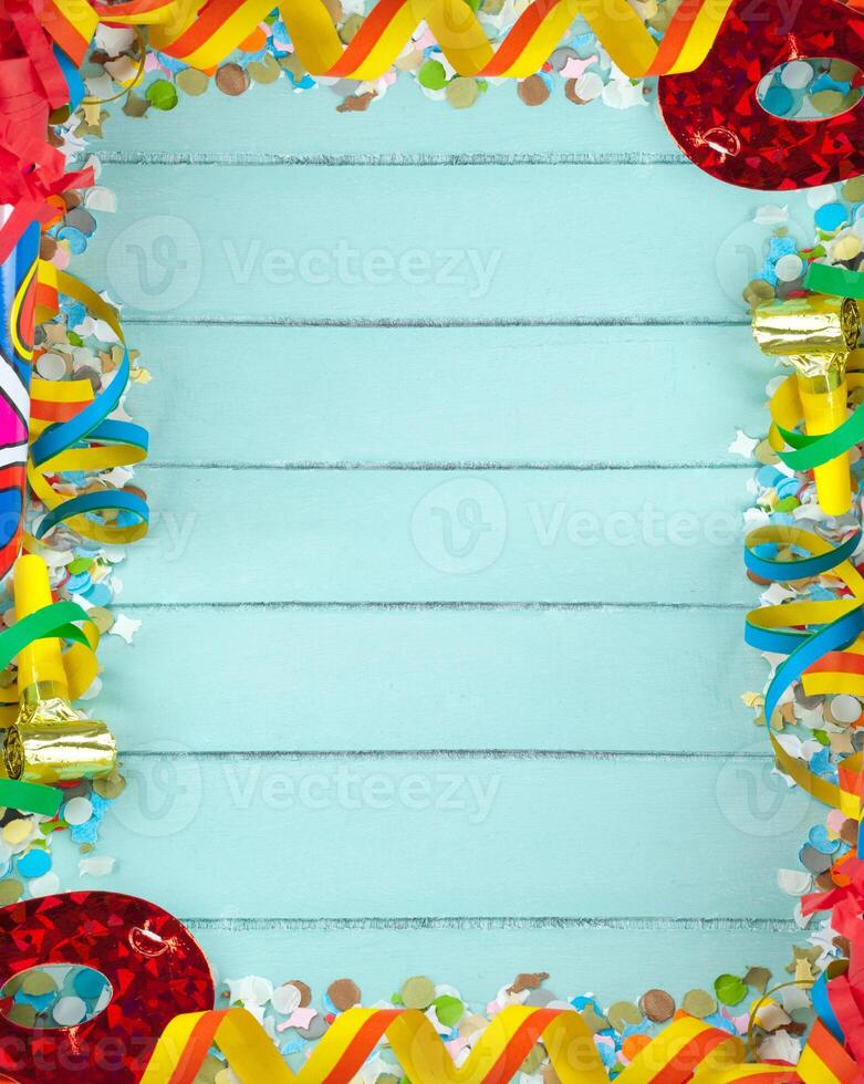 A colorful border with ribbons and confetti on a wooden background photo