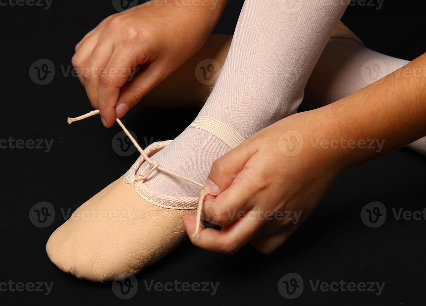 A person tying a shoe with a string photo