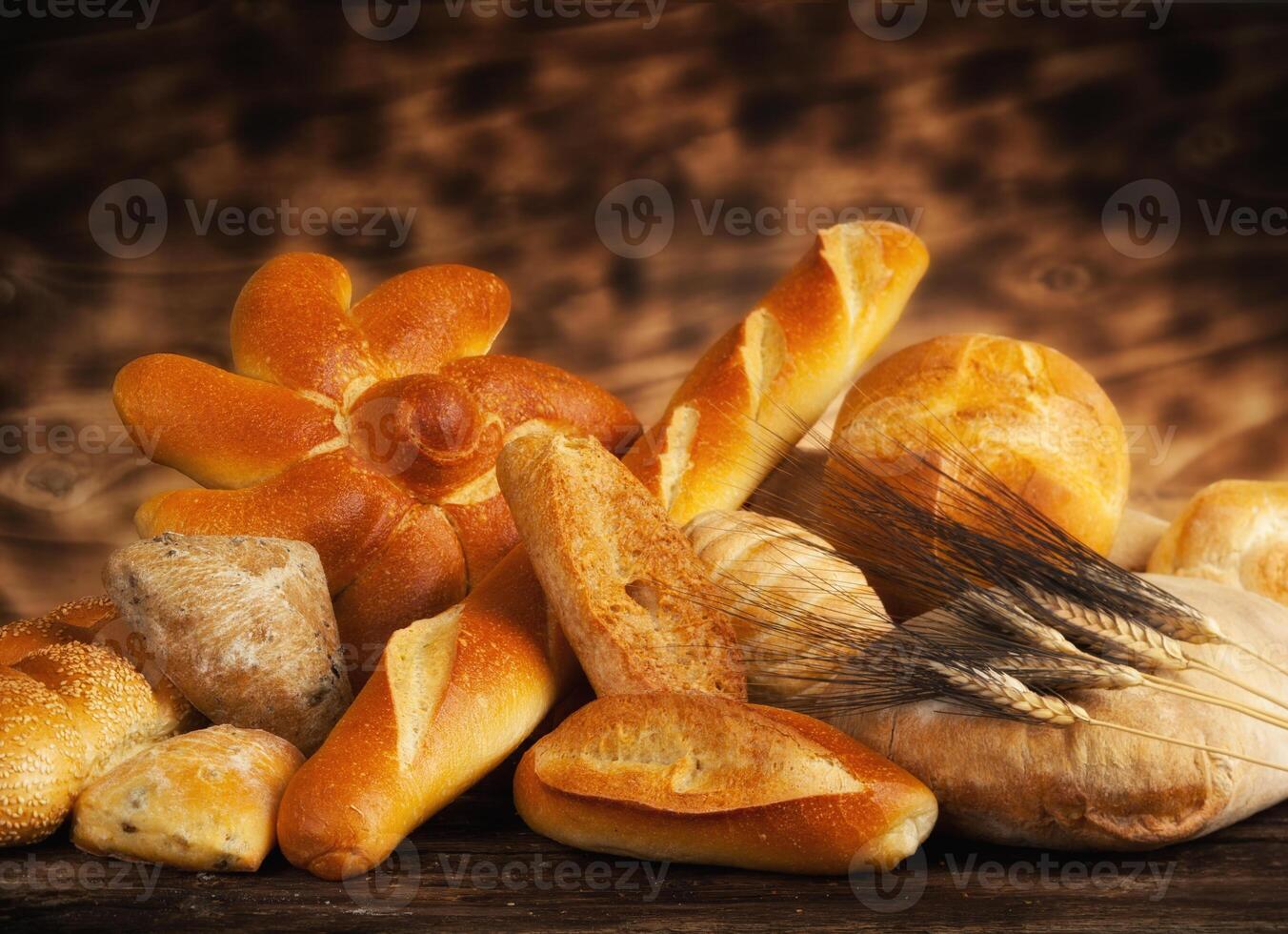 A variety of breads and rolls on a wooden table photo