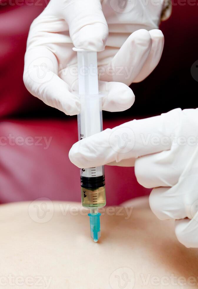 A person getting an injection into their arm photo