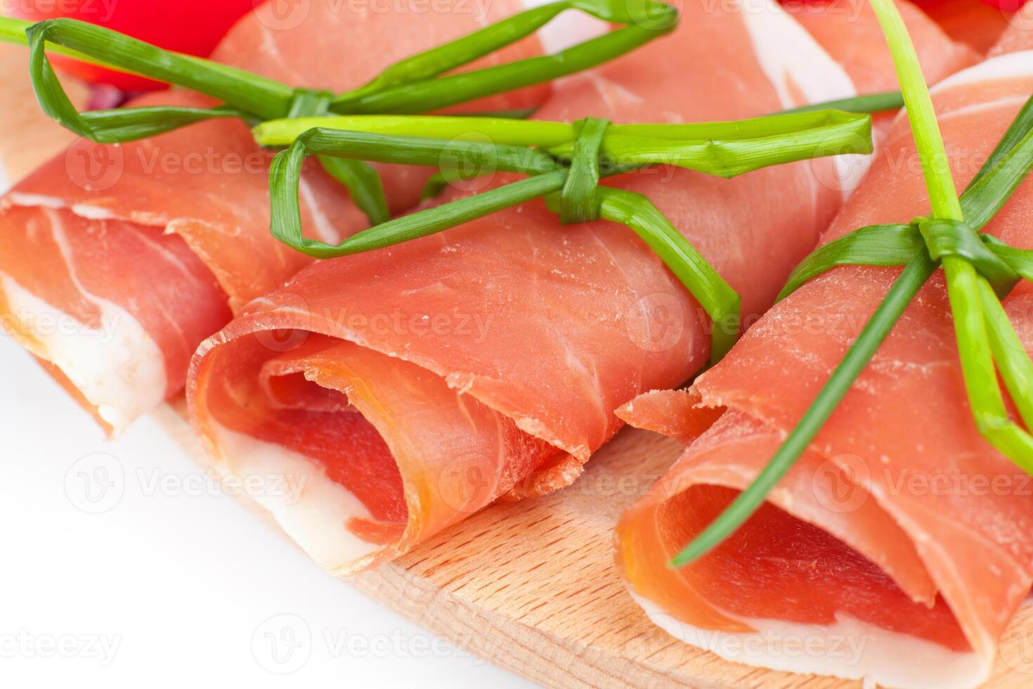 A plate with ham wrapped in bacon and tomatoes photo