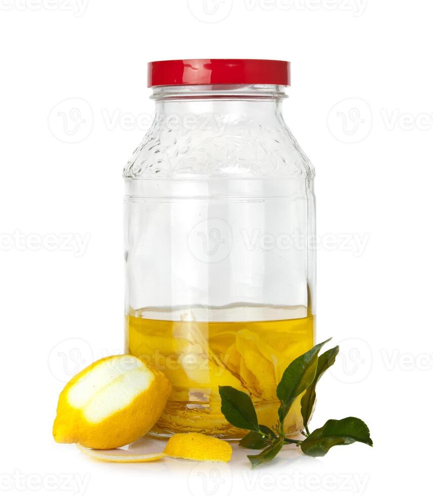 A jar of lemon oil with a lemon slice and a leaf photo