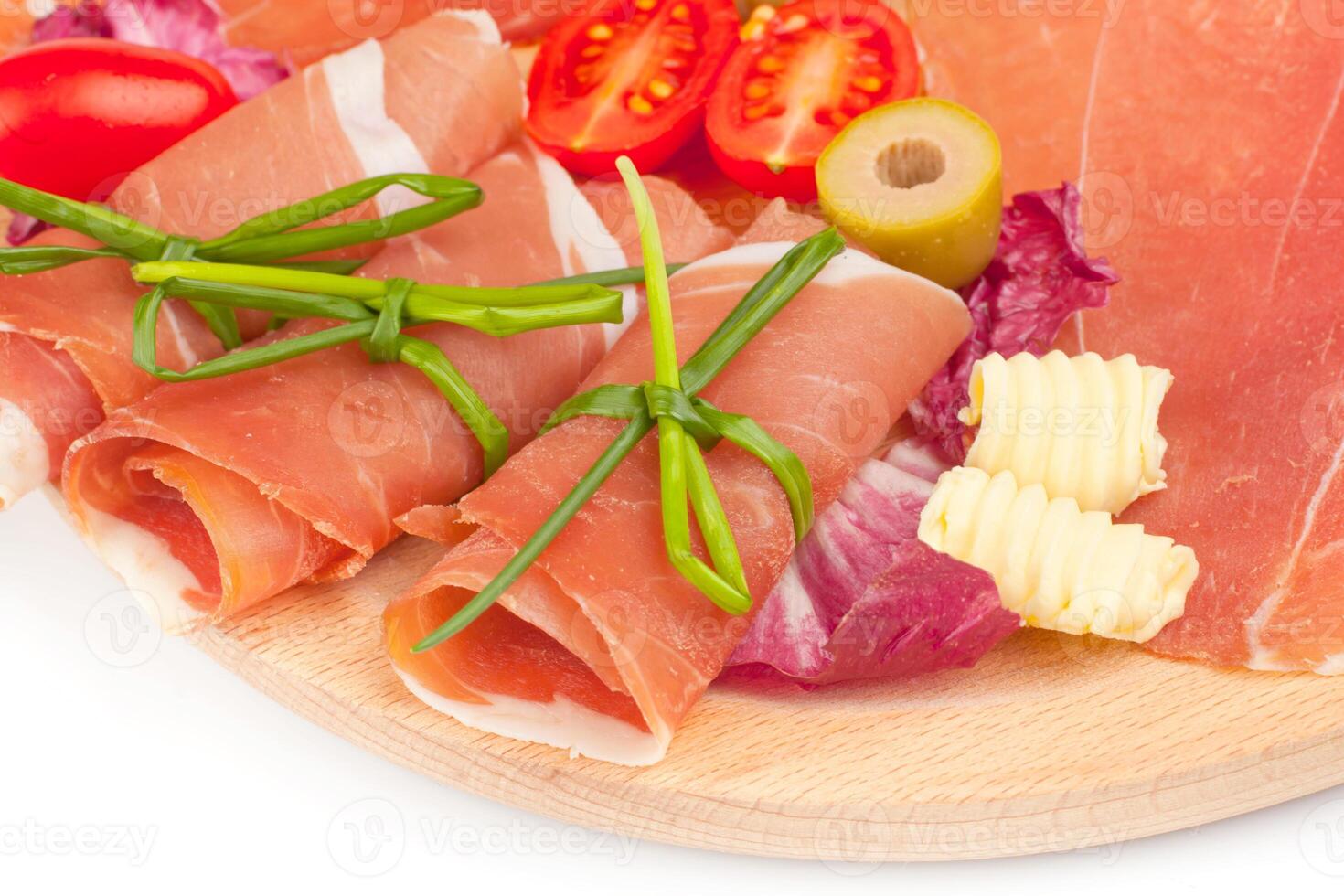 A plate with sliced ham, tomatoes, and cheese photo