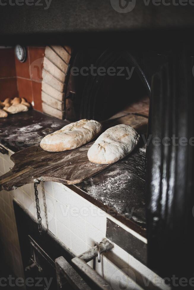 Production of baked bread with a wood oven in a bakery. photo