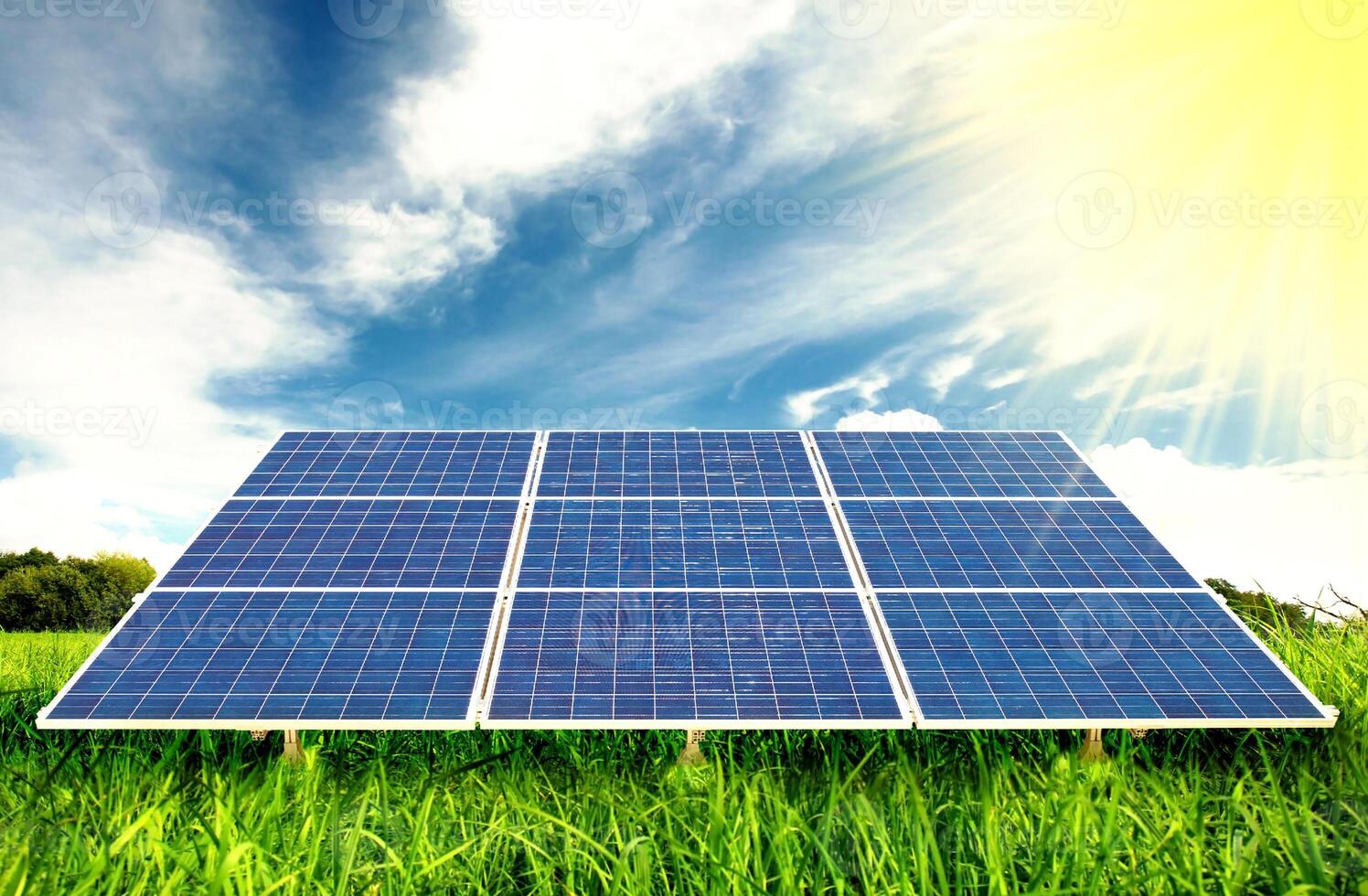 Solar panels on a green field with blue sky photo