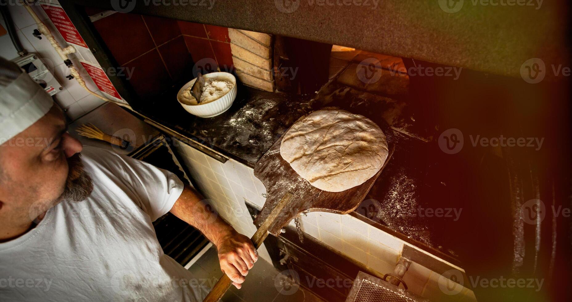 Production of baked bread with a wood oven in a bakery. photo
