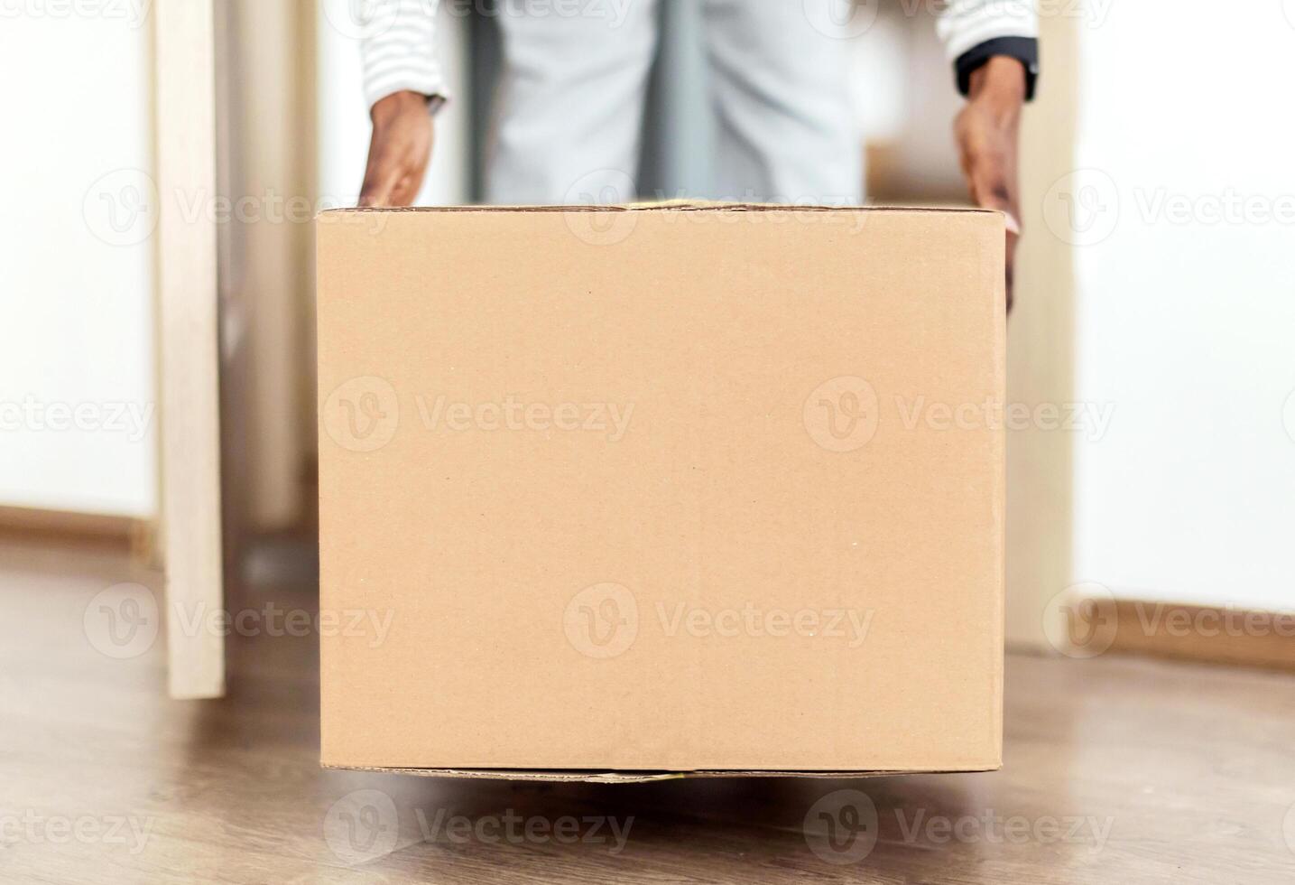 Parcel Delivery. Unrecognizable African American Lady Putting Big Cardboard Box On Floor Entering Home After Receiving Package From Courier. Cropped Shot Of Female Carrying Box Indoor. Panorama photo