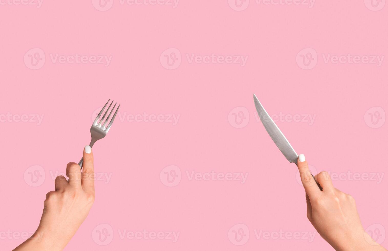 Cropped view of girl hands holding metal knife and fork on pink background, panorama photo