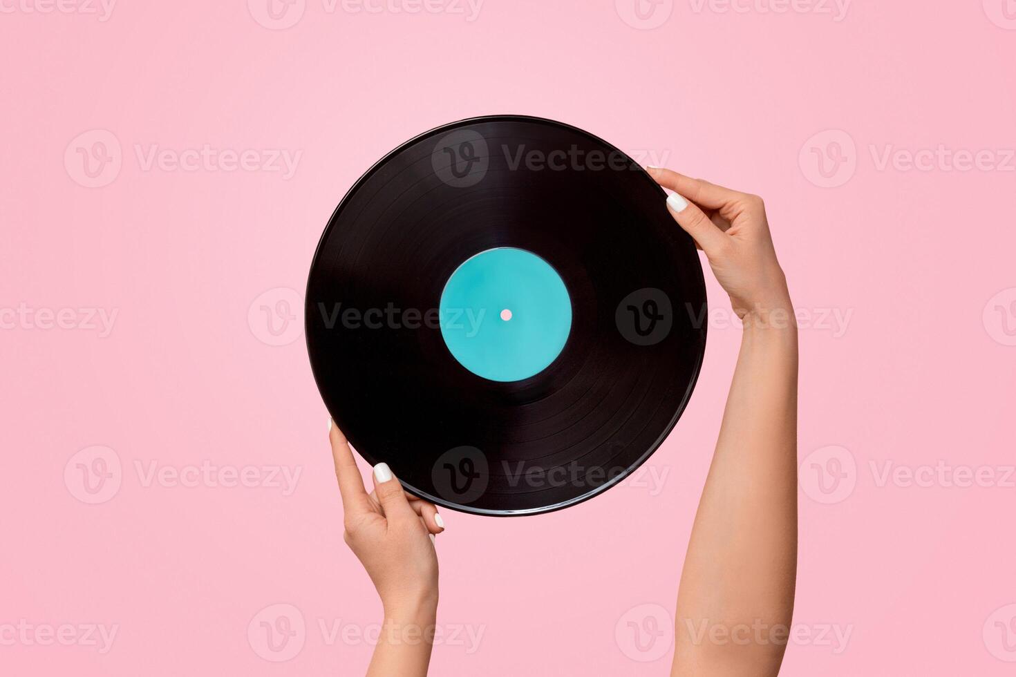 Young woman holding gramophone record on pink background, close up. Copy space. Panorama photo