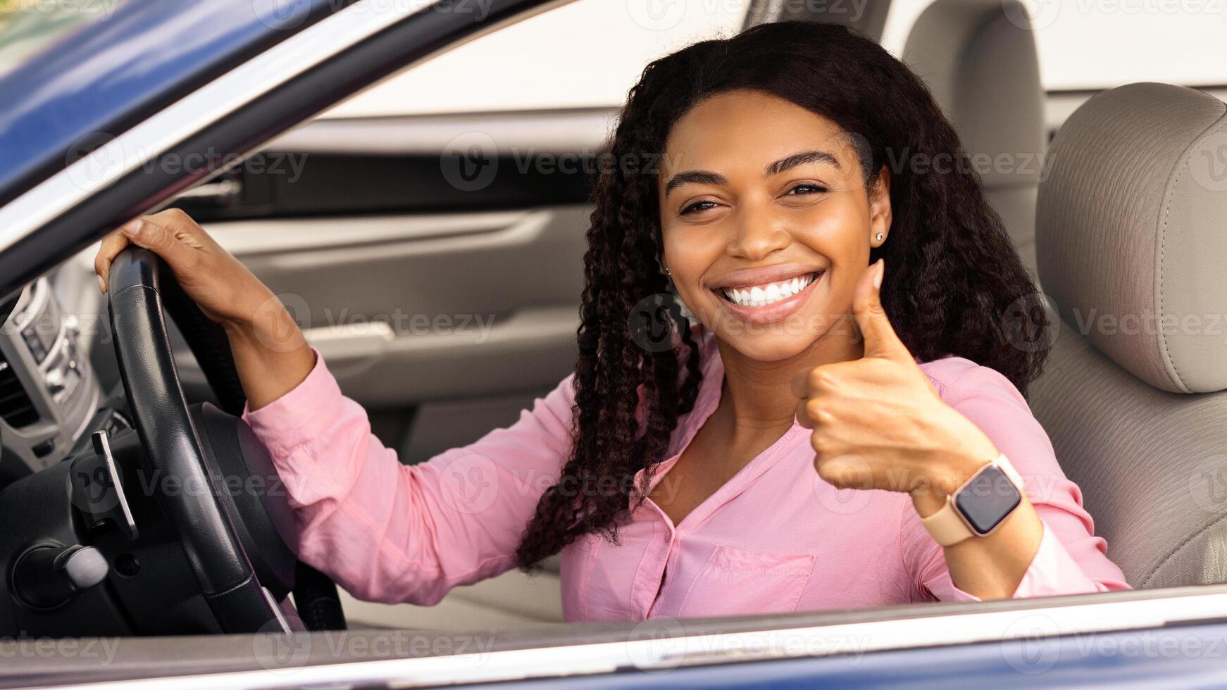 Great Perfect Car. Happy African American Lady Showing Thumb Up Sign Gesture, Sitting In New Automobile Buying Modern Vehicle In Dealership Store, Enjoying Vacation, Looking At Camera Through Window photo