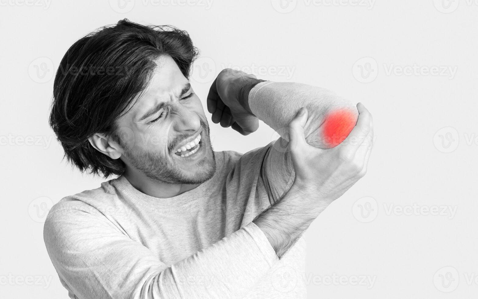 Arthritis concept. Guy has elbow pain, highlighted in red photo