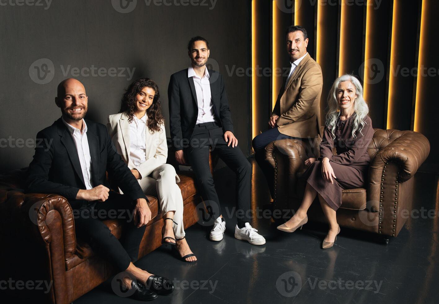 A group of executives poses confidently in a stylish office space. They showcase their collaboration and leadership, reflecting a dynamic corporate culture focused on teamwork. photo