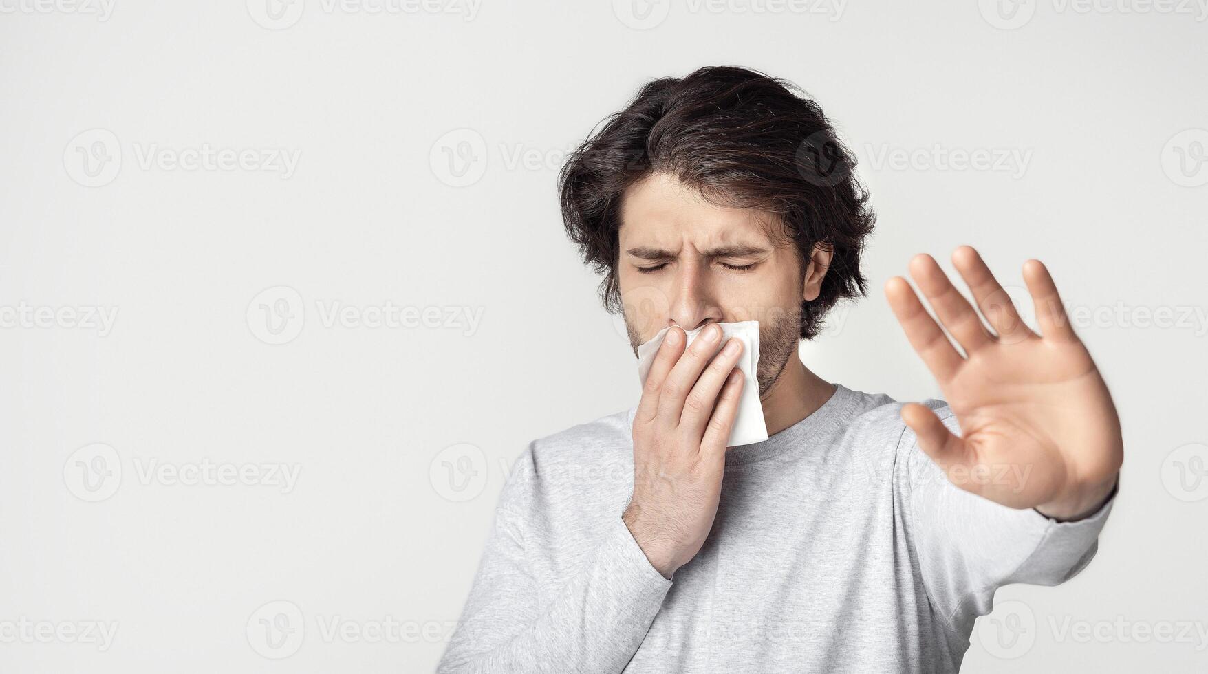 Afraid of dentist. Upset man with toothache shut his mouth with napkin photo