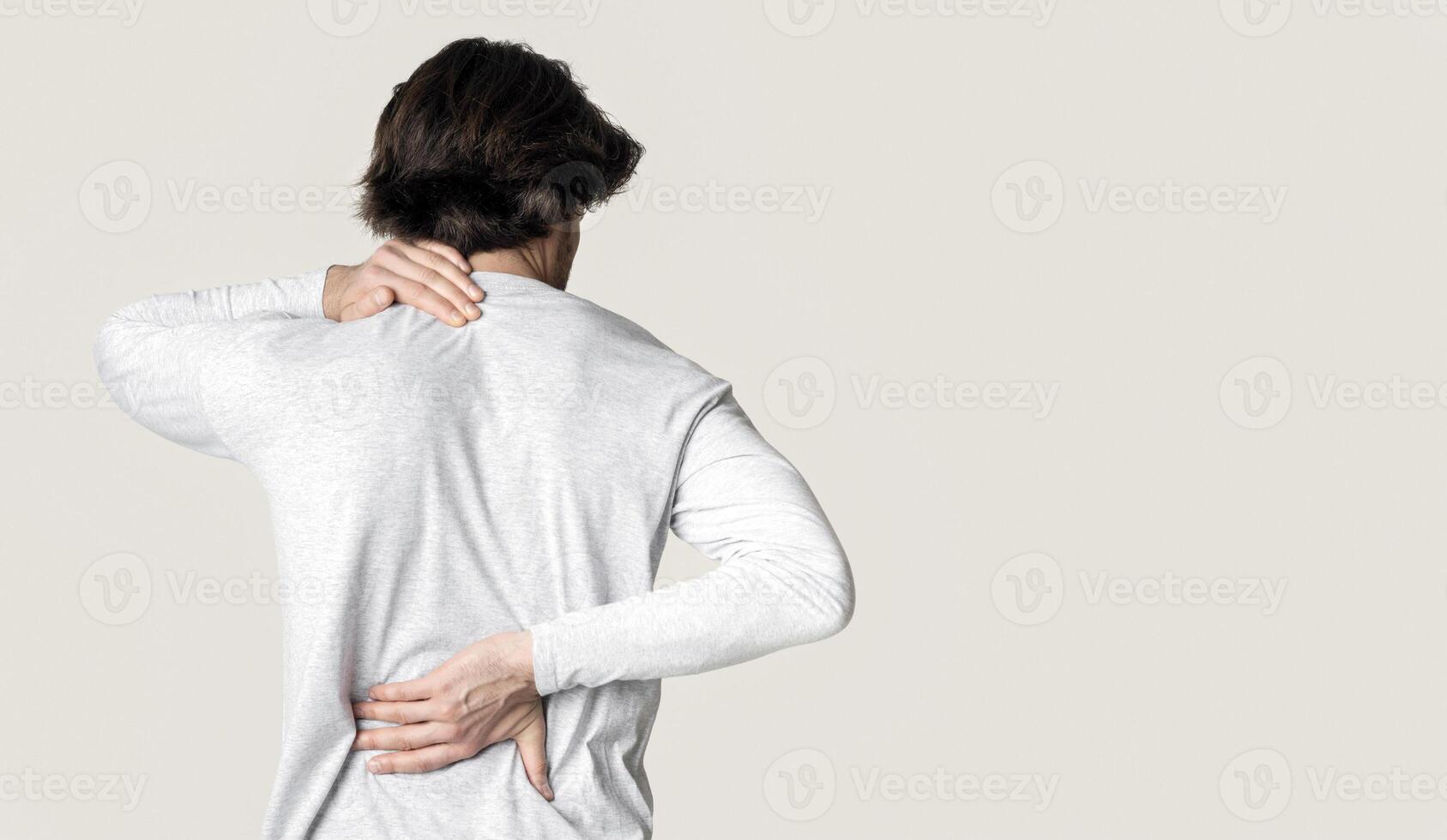 Man suffering from back and neck pain, panorama, isolated gray background photo