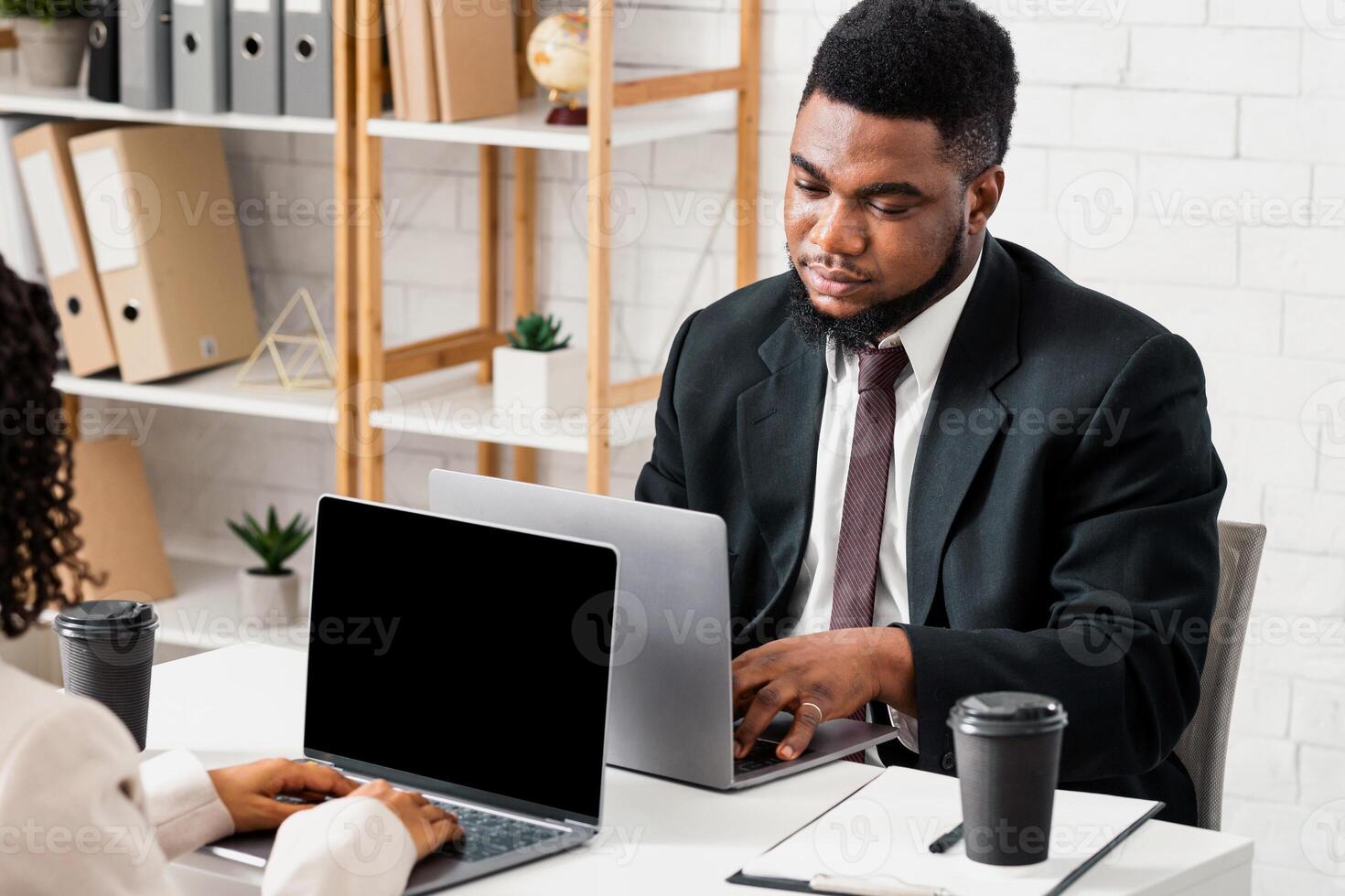 Young black man working with his female colleague, feeling bored, doing dull task at open space company office. Successful coworking and collaboration concept. Free space photo