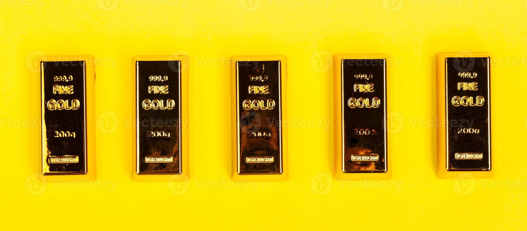 Bars of gold bullion on yellow background. photo