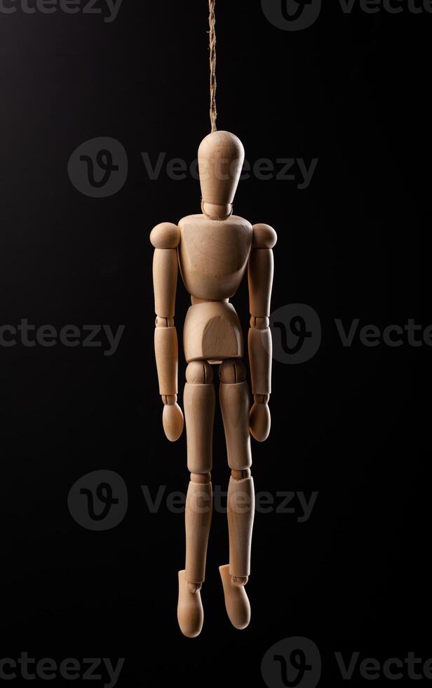 Wood figure hanged with a rope Isolated on black background. photo