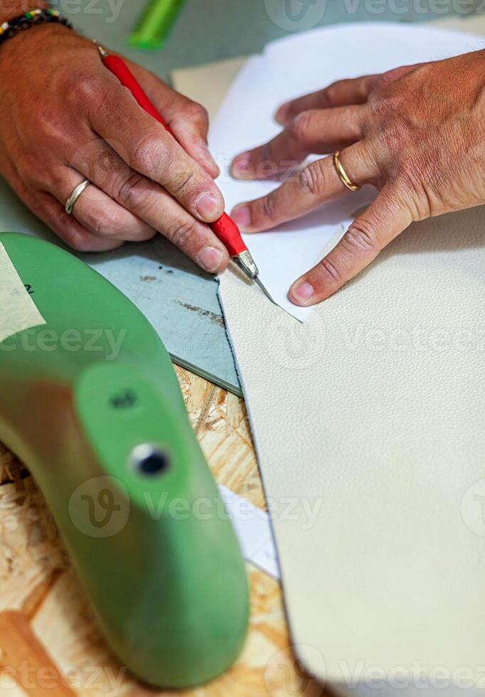 Shoe designer working with leather. photo