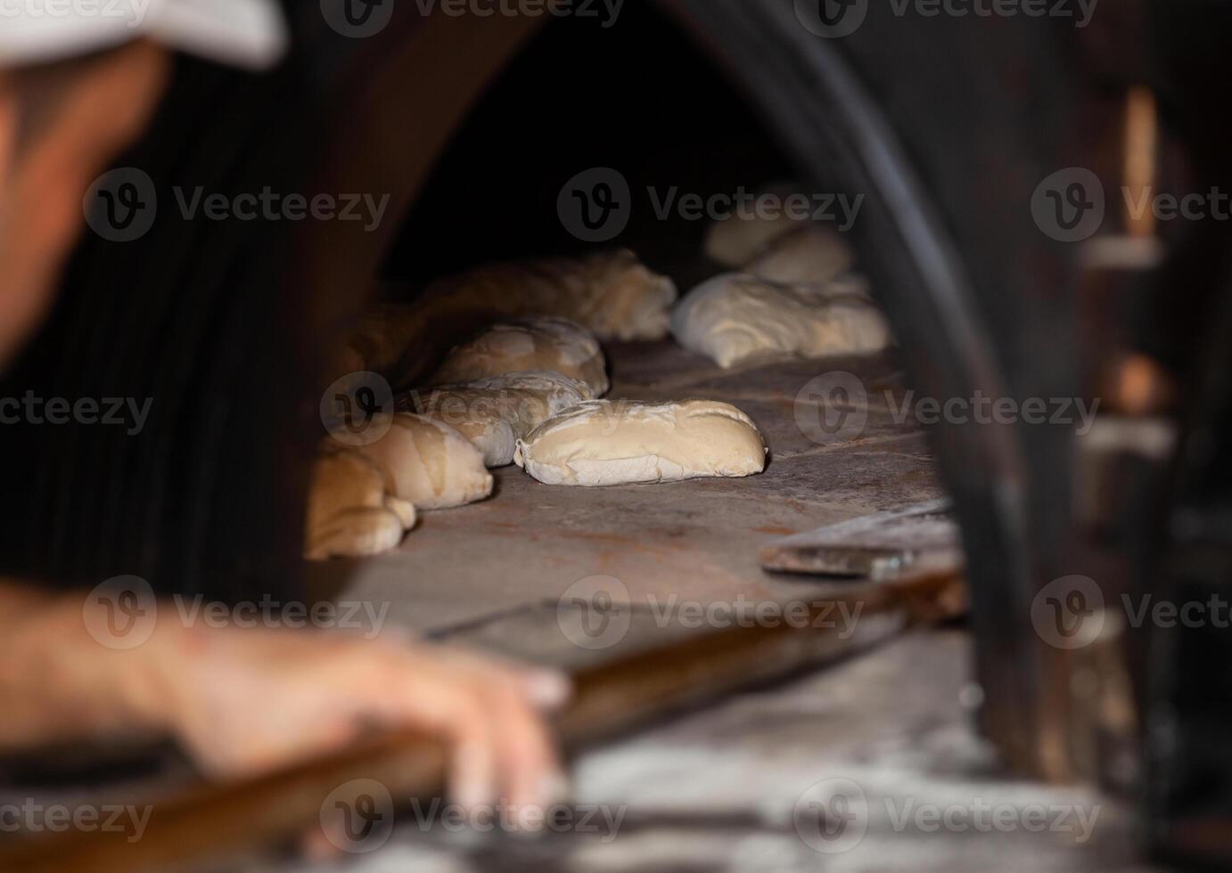 Production of baked bread with a wood oven in a bakery. photo