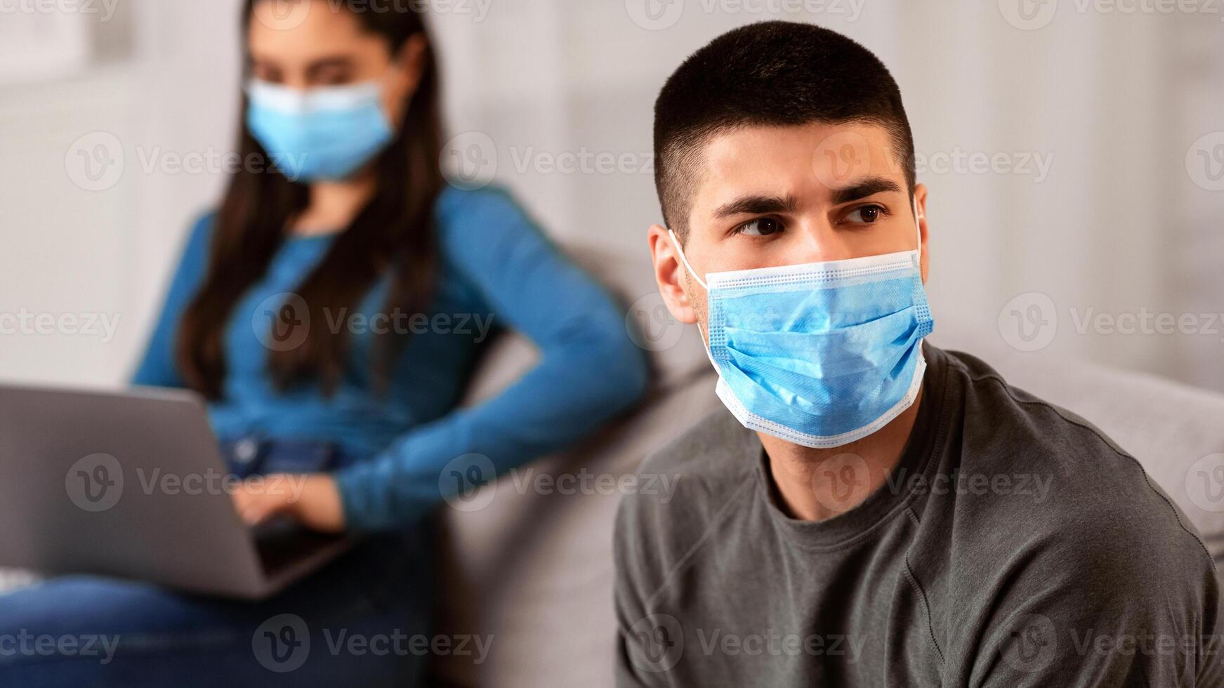 Couple Crisis During Quarantine Concept. Wife using laptop, working from home, not paying attention to husband photo
