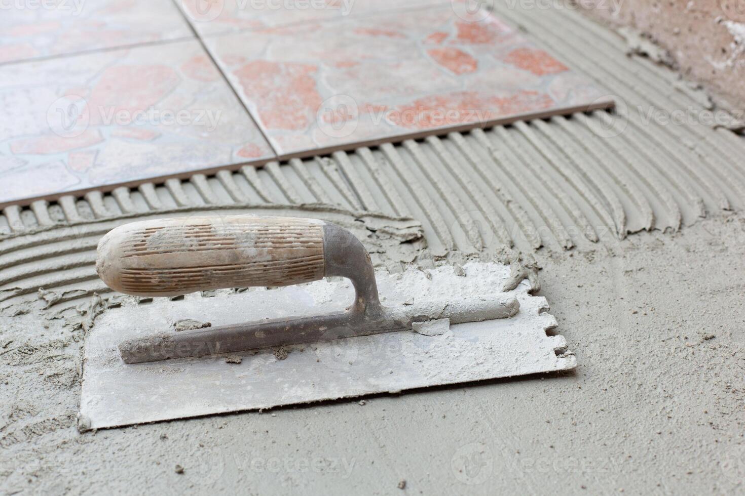 Notched spatula for applying adhesive for tile photo