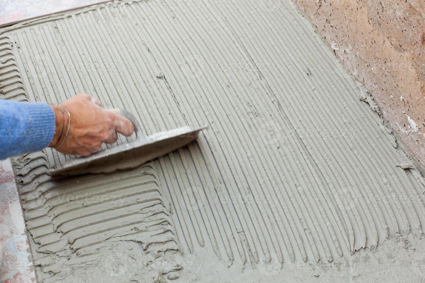 Tiler works with flooring. photo