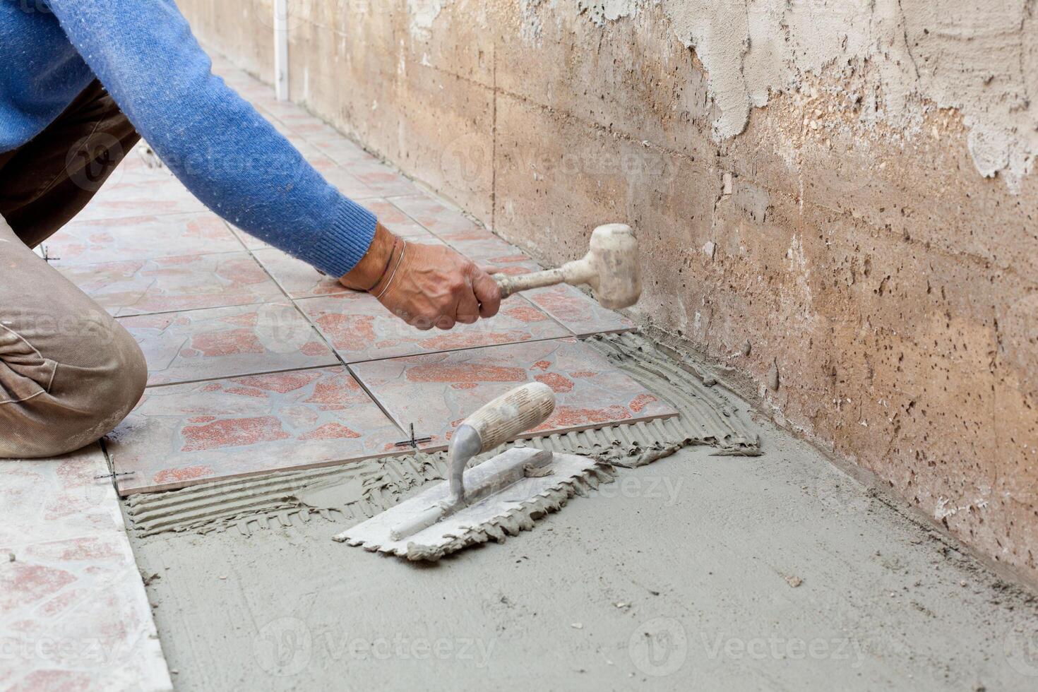 Tiler works with flooring. photo