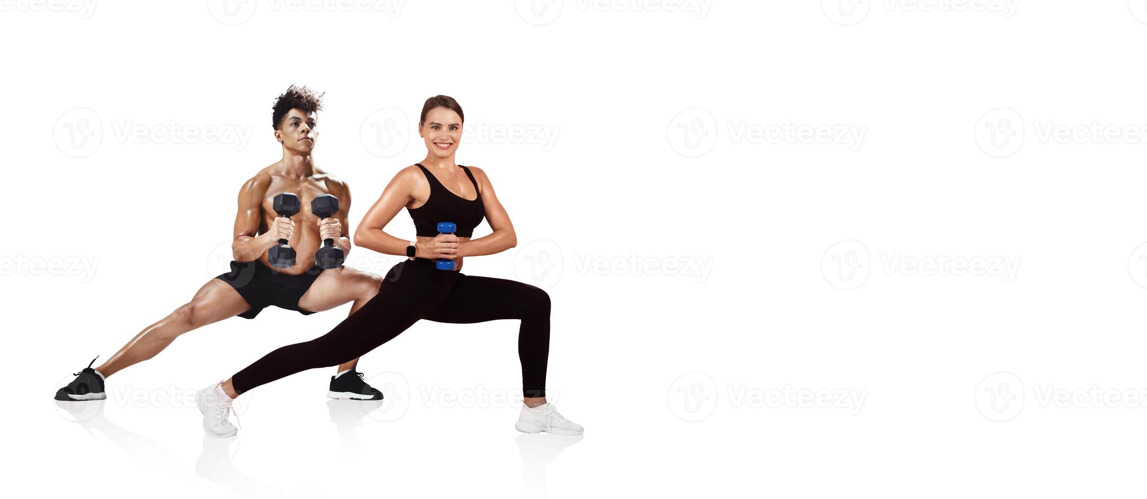 Two individuals engage in a workout session, performing lunges while holding dumbbells. The setting emphasizes strength training and physical fitness. photo