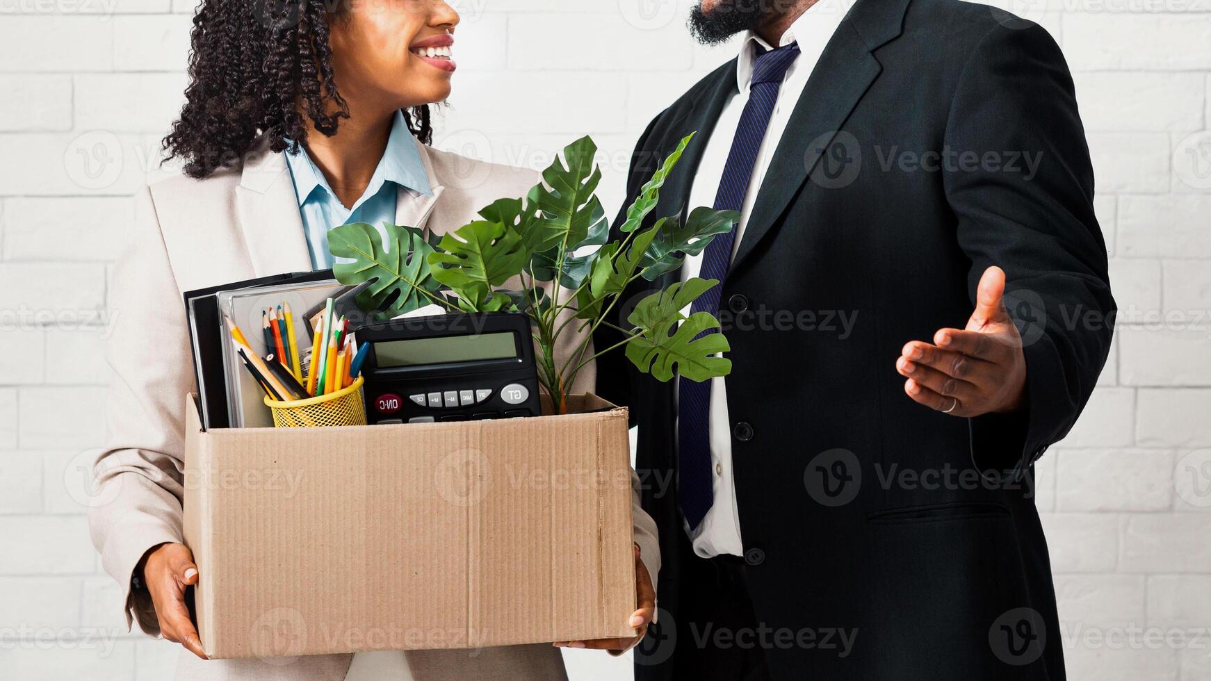 Happy young woman with box of personal things being hired to work in business company, meeting her new boss photo