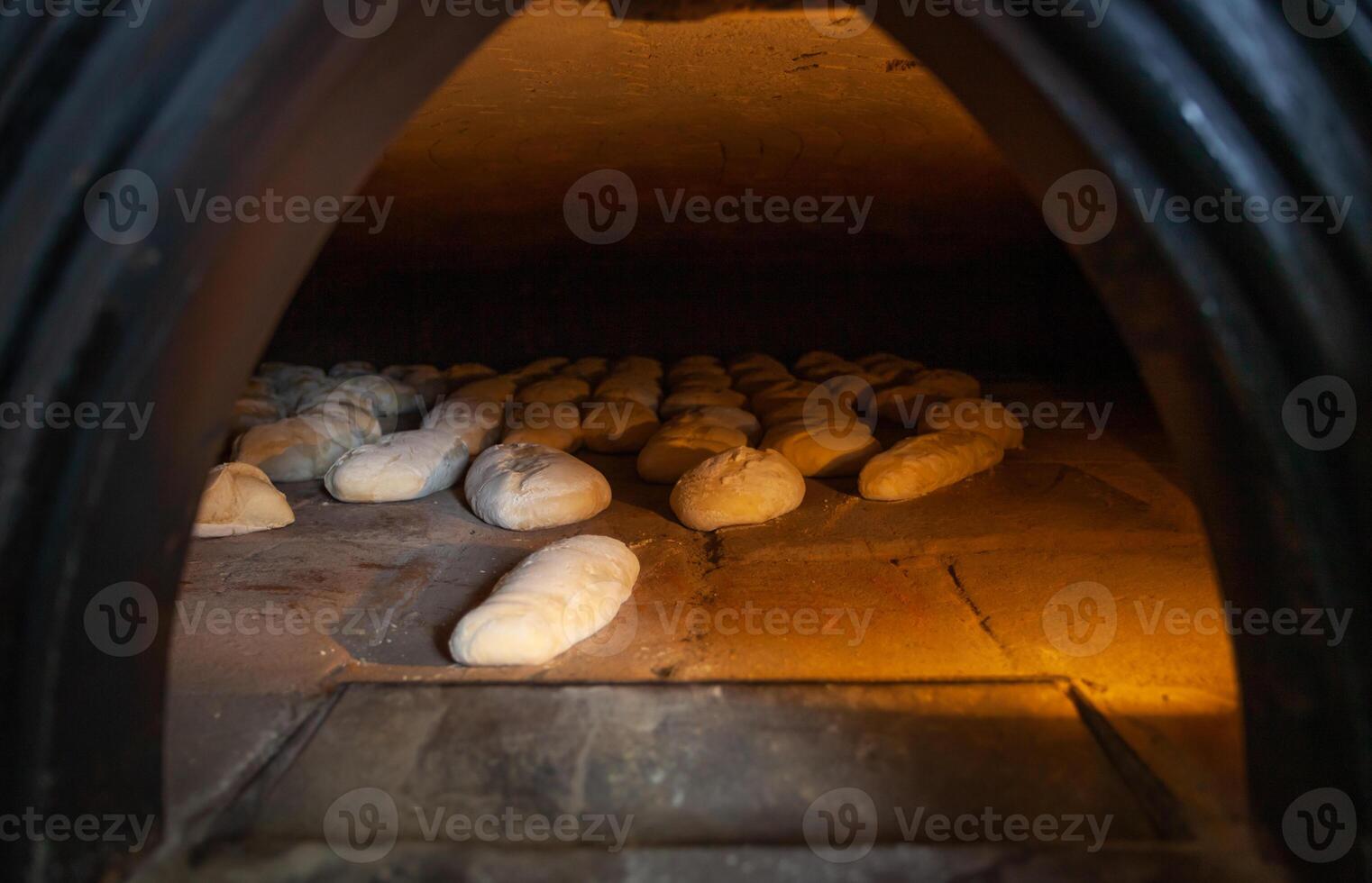 Production of baked bread with a wood oven in a bakery. photo