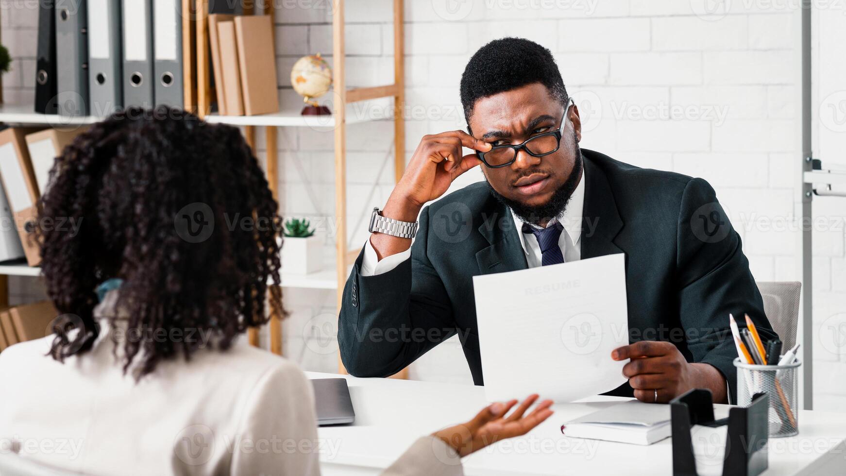 Searching for work concept. Serious human resources manager looking through applicant's resume on job interview in office photo