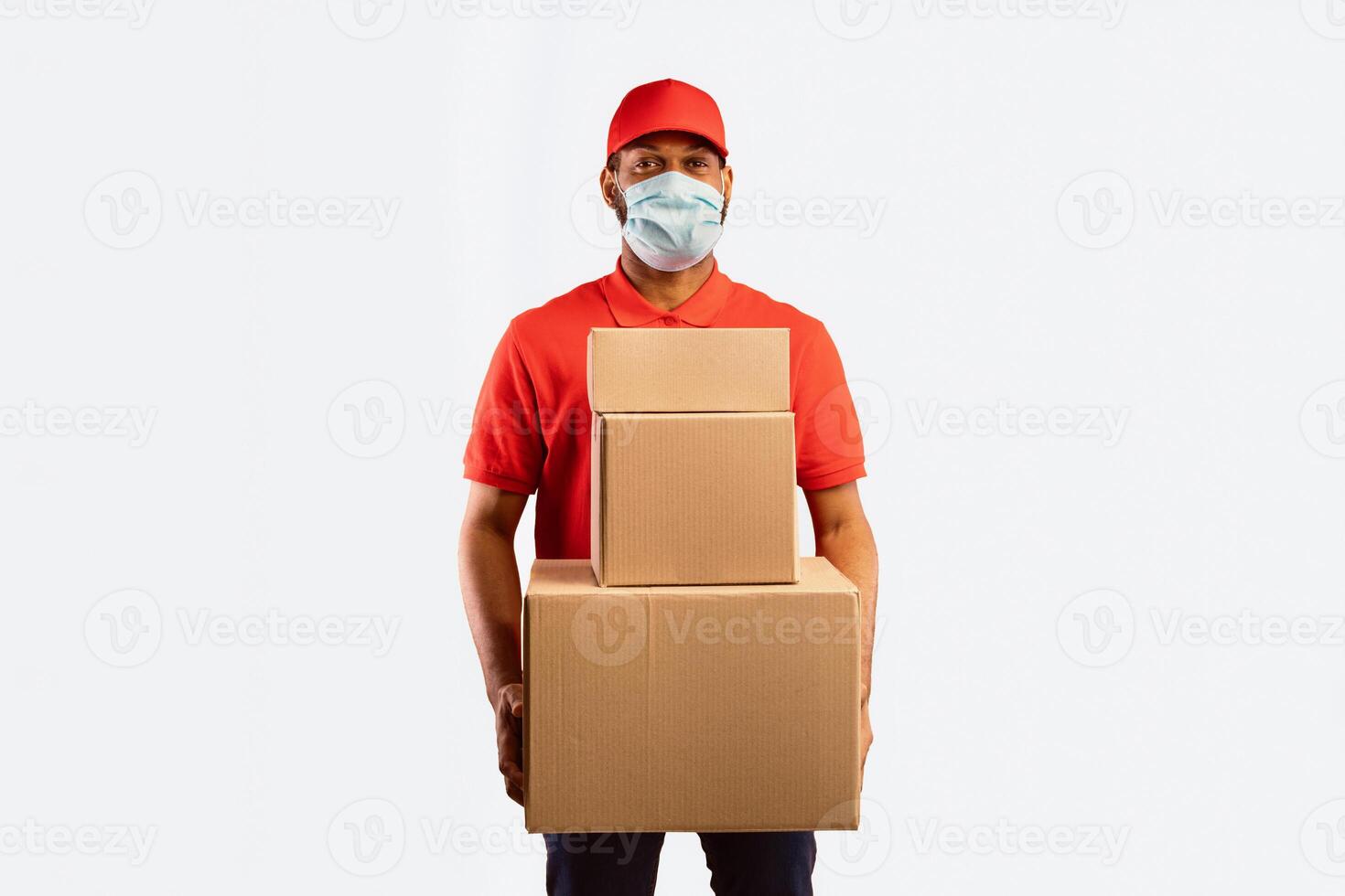 Quarantine Delivery Service. African American Courier Holding Boxes Delivering Items Purchased Online Posing On Yellow Studio Background Wearing Protective Mask. photo