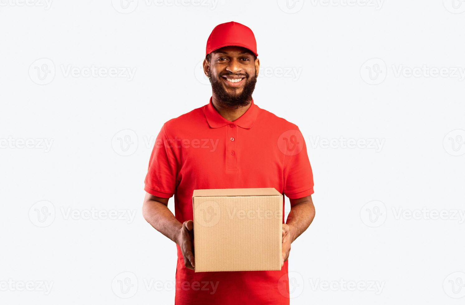 African American Delivery Man Holding Cardboard Box Delivering Online Order To Customer's Home Standing Over Yellow Background In Studio photo