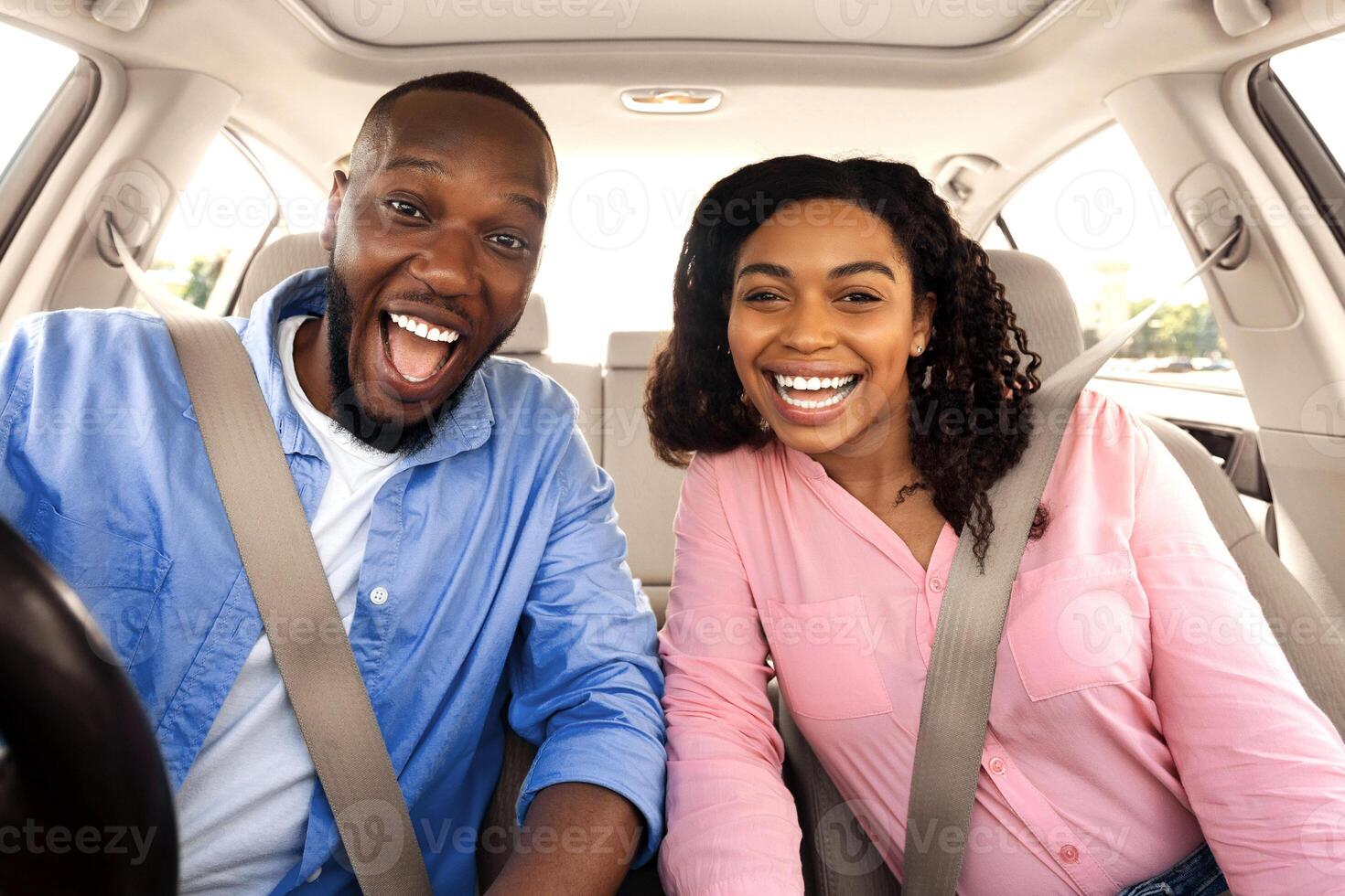 New Car Owners. Portrait of smiling African American family sitting in modern luxury car, happy excited young black couple posing looking at camera, choosing buying new car in dealership store shop photo