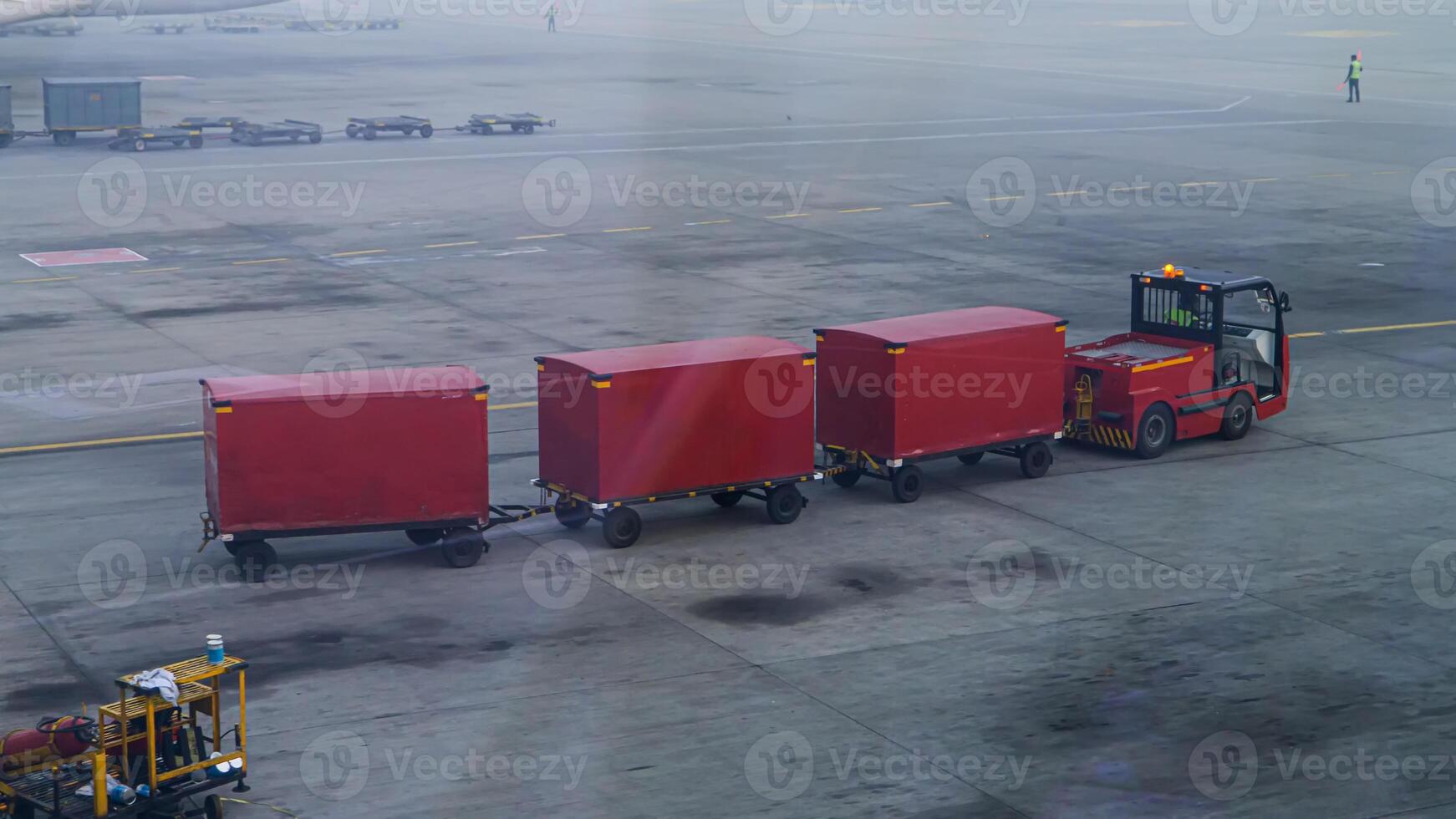 A red truck is pulling a red box on a tarmac photo