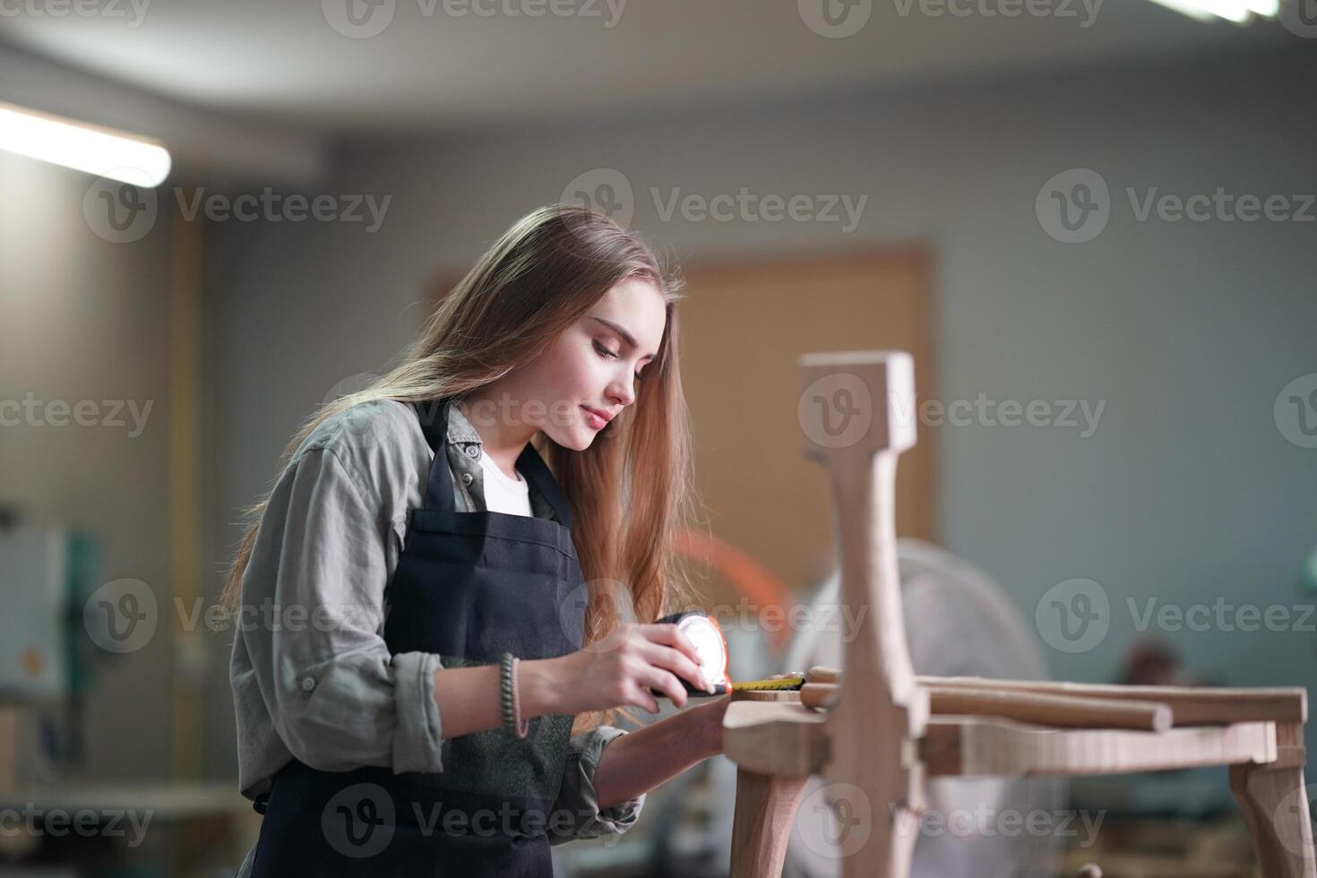 A woman is working on a wooden chair photo