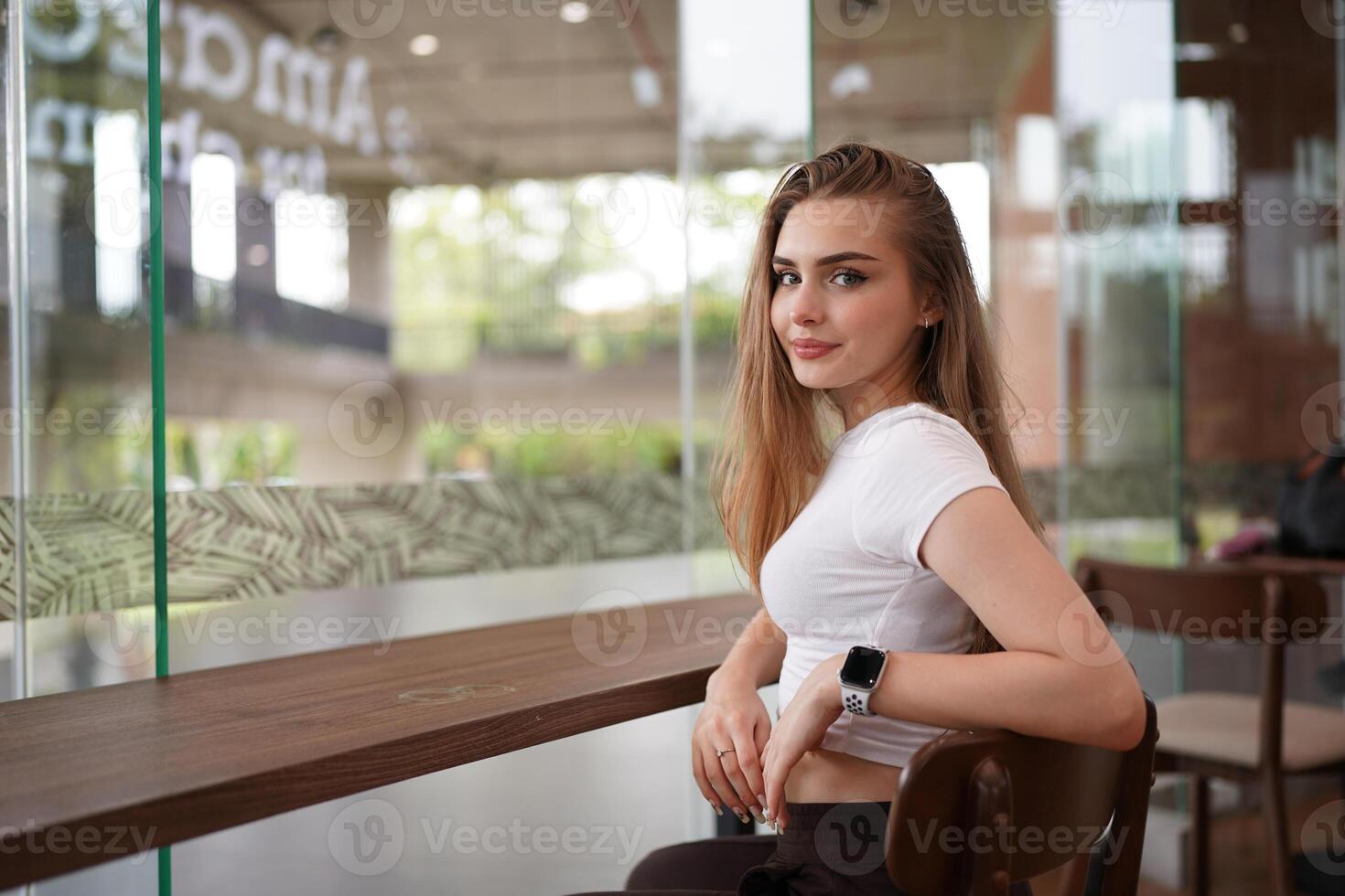 A woman sitting at a table in front of a window photo