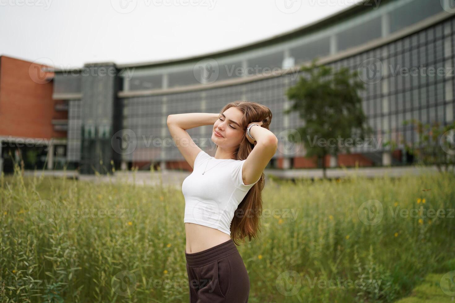 A woman in a field with her hands on her head photo