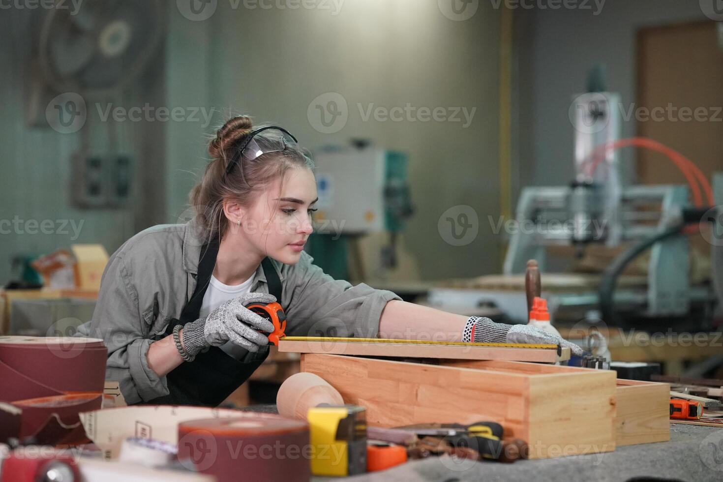 A woman working on a wooden box in a workshop photo