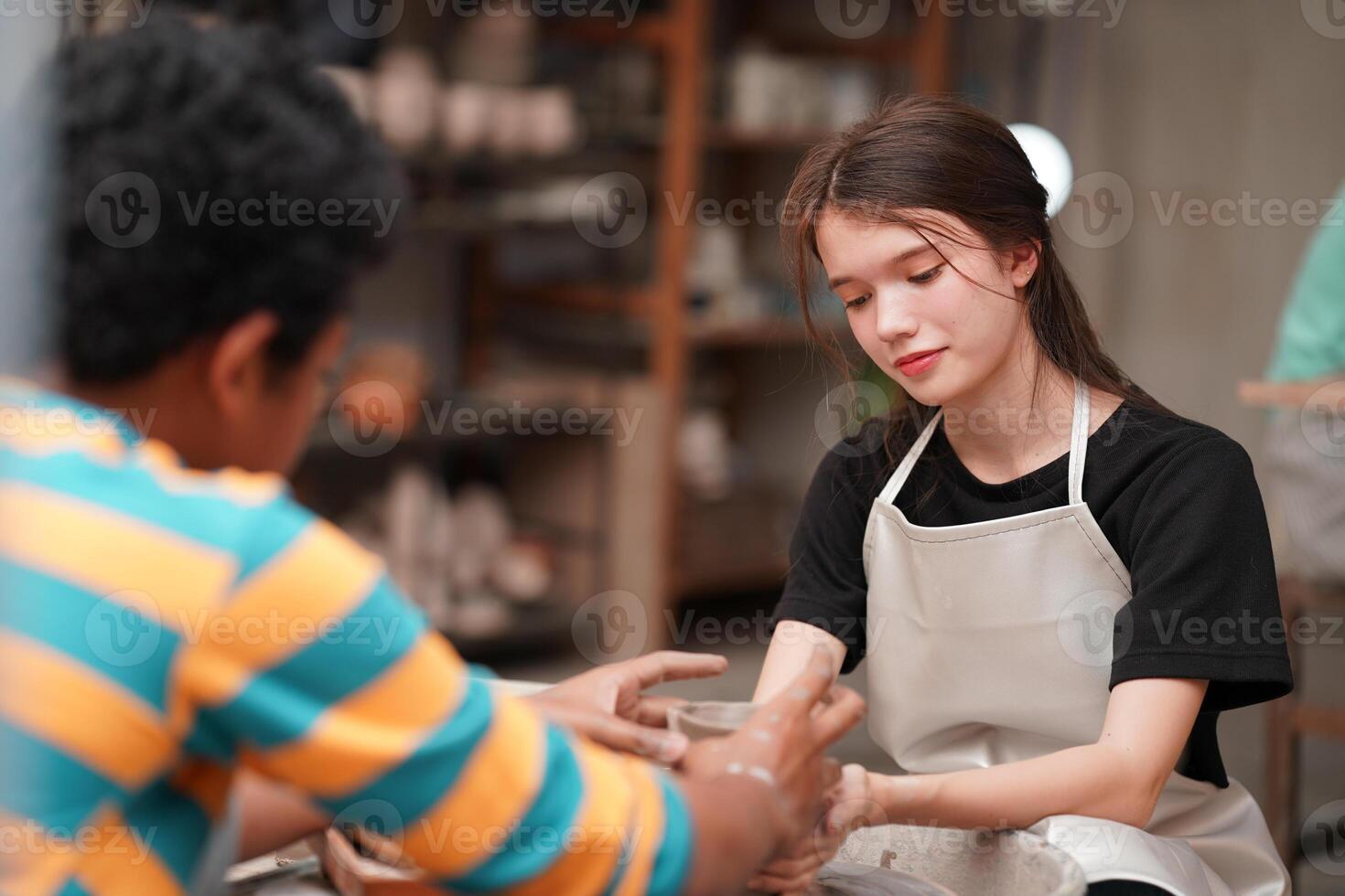 A woman is making a pottery bowl with a man photo