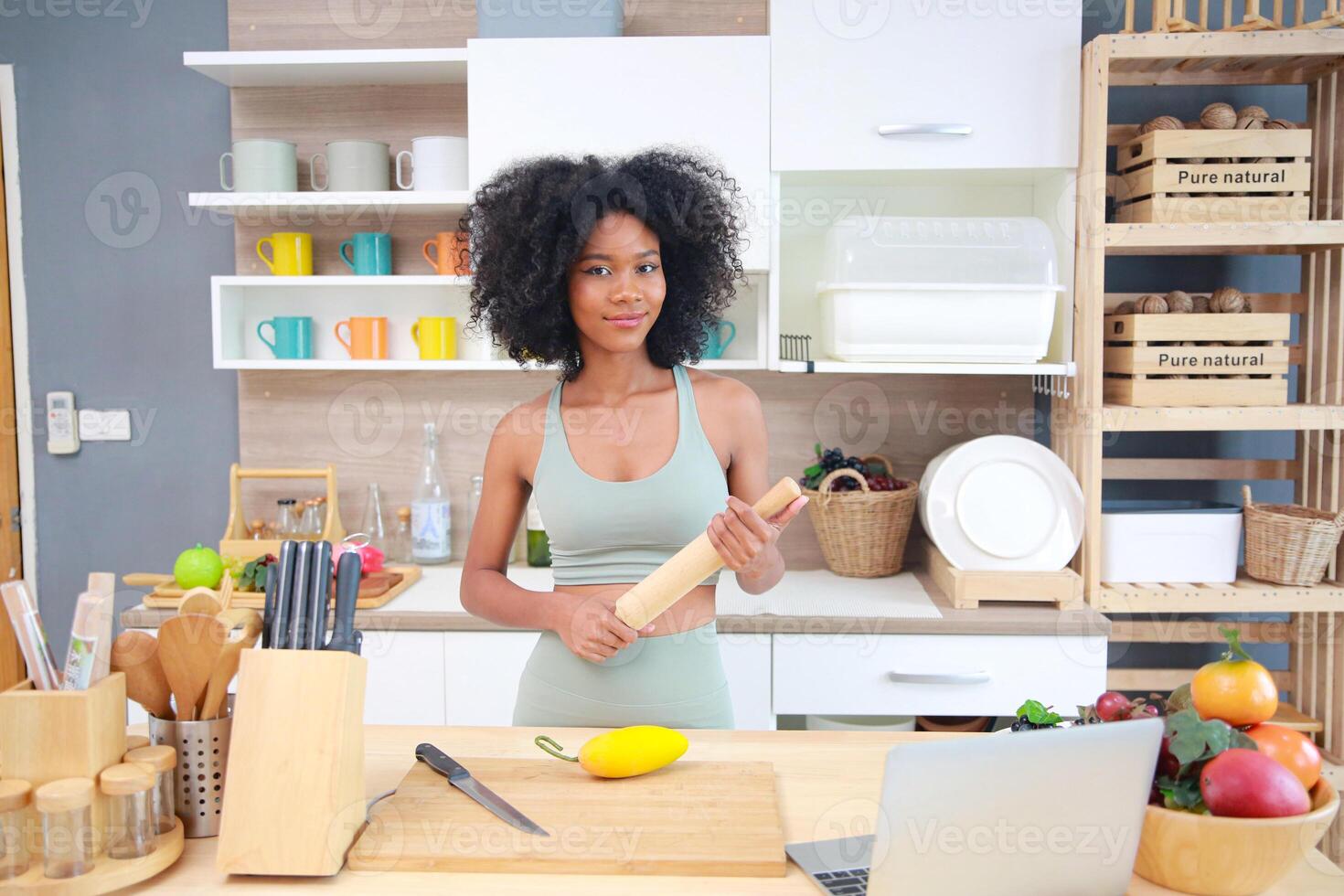 A woman in a kitchen holding a knife photo