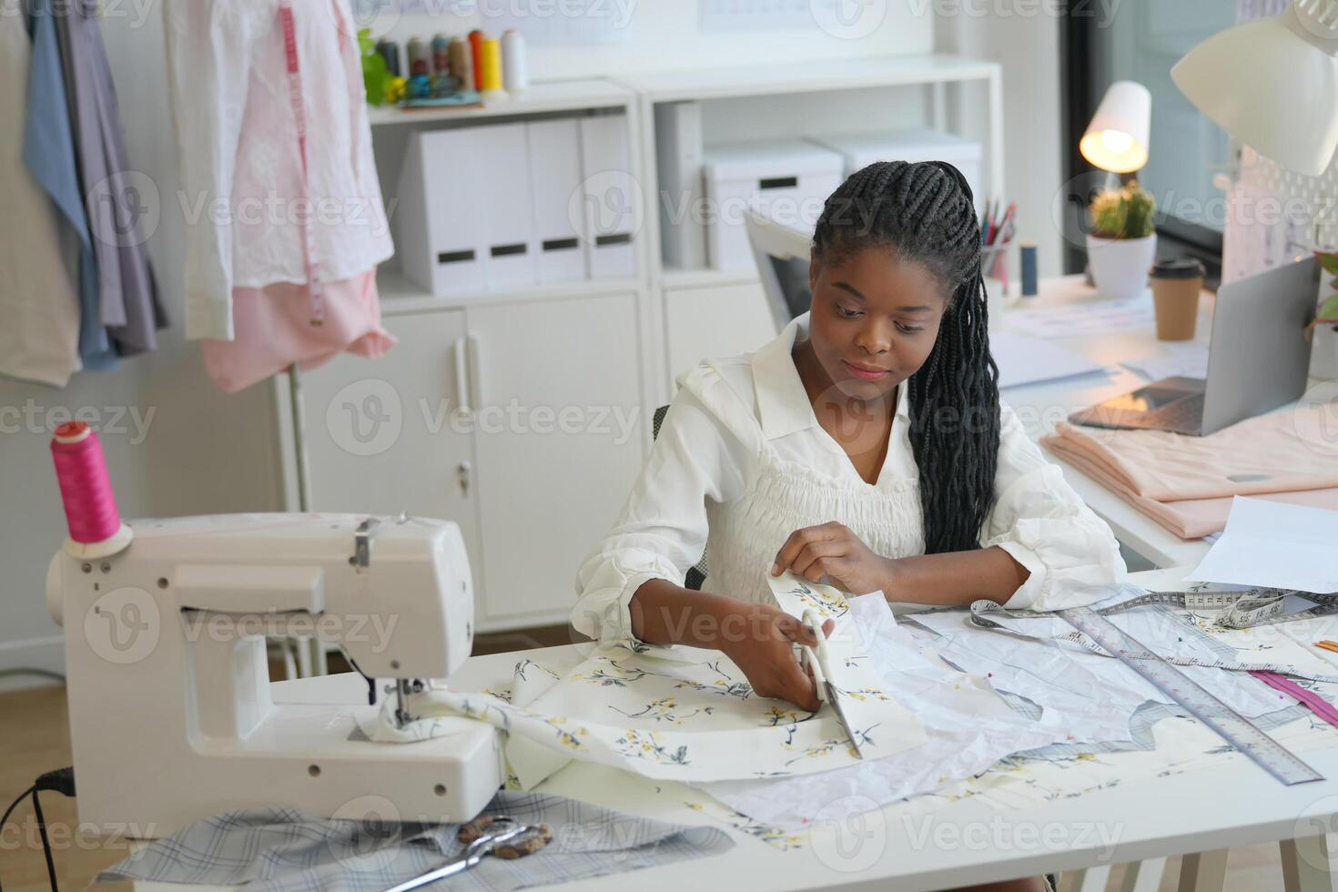 A woman is working on a sewing machine photo