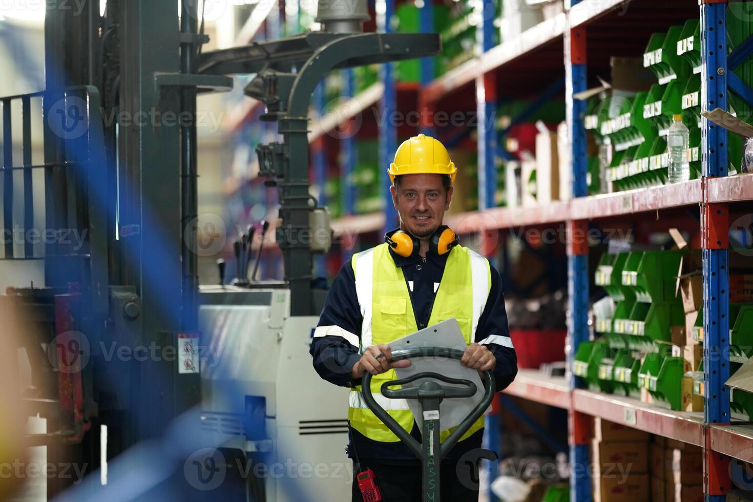 A worker in a warehouse with a forklift photo