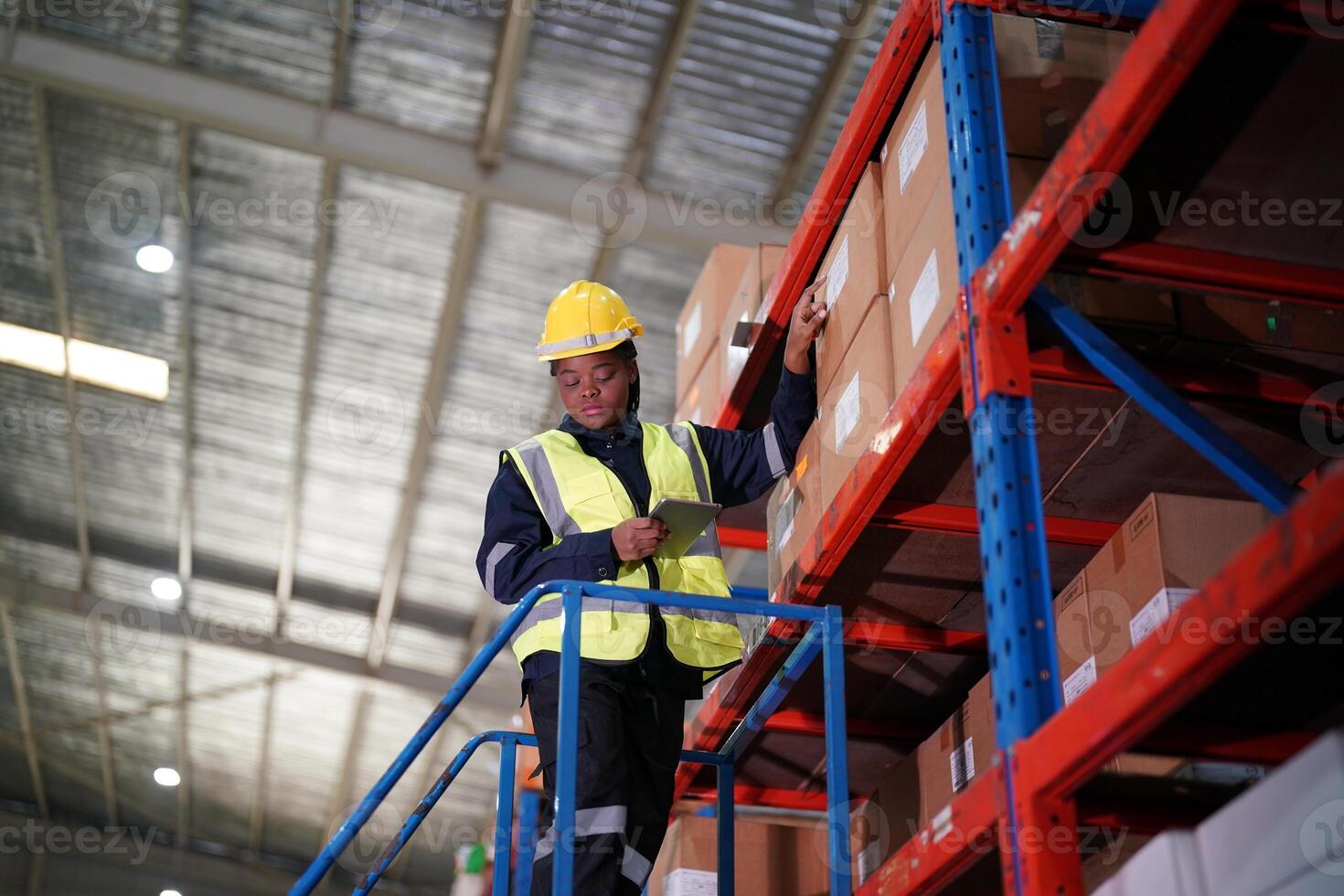 A man in a hard hat and safety vest standing on a shelf photo
