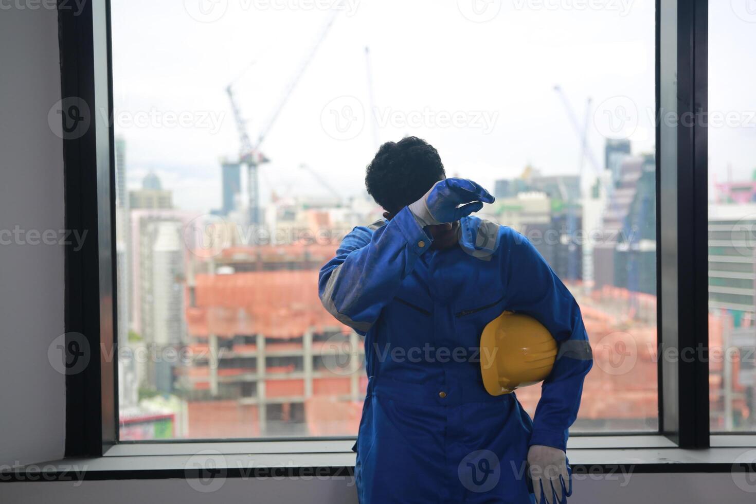 A man in a blue suit standing in front of a window photo